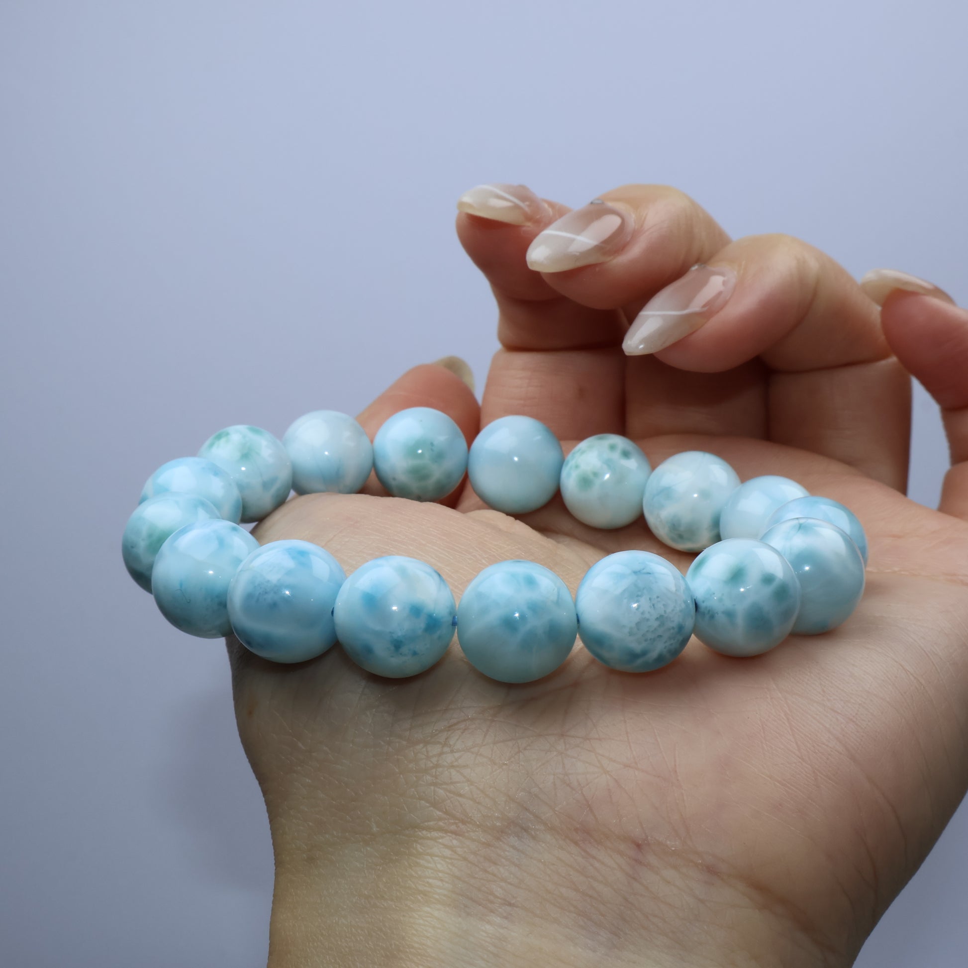 Larimar bracelet displayed on palm for scale and color comparison