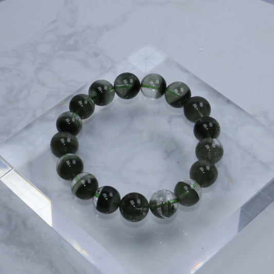 Flat lay of Green Phantom Quartz bracelet on clear acrylic block