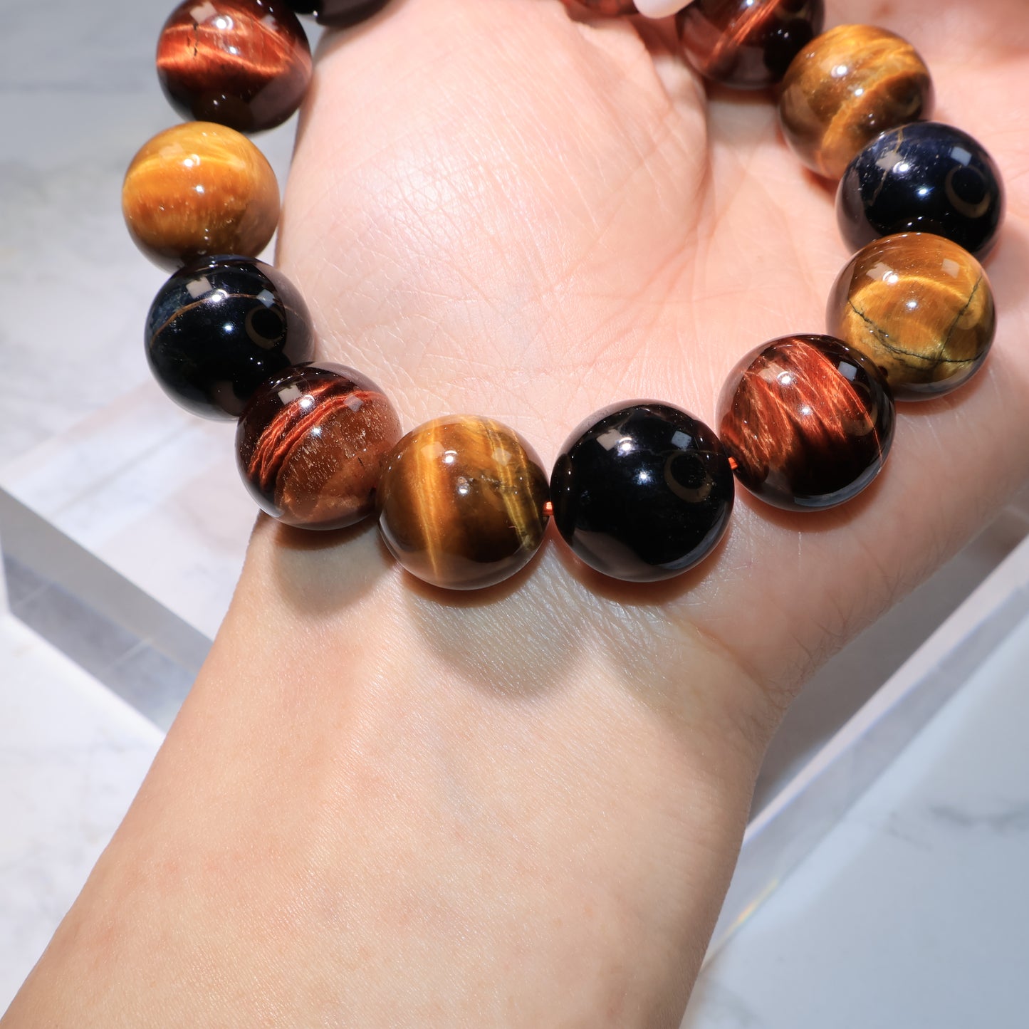 Side view of bracelet on wrist highlighting the golden and red tiger eye beads.