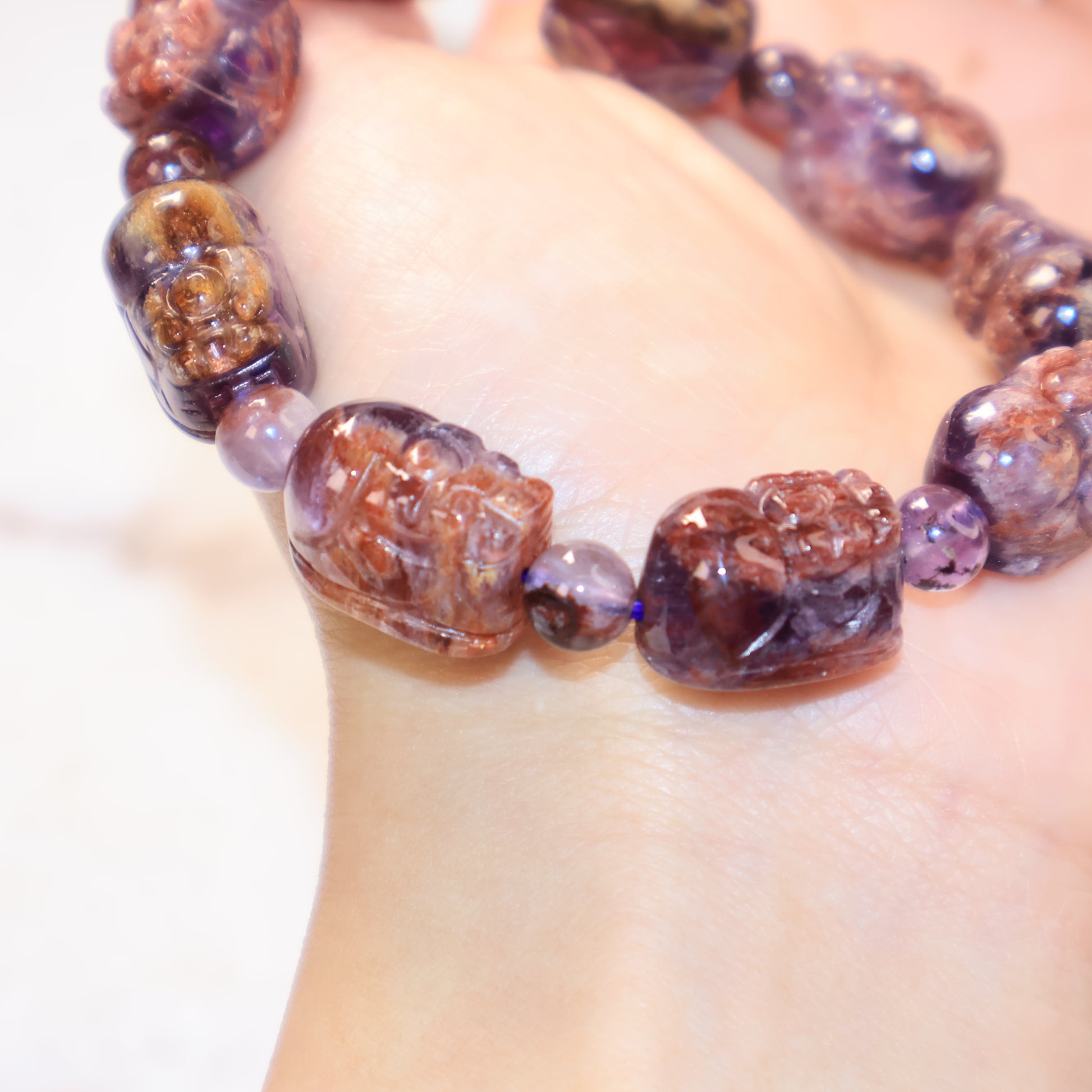 Close-up of carved Pixiu crystal bracelet showing glossy translucent crystal details