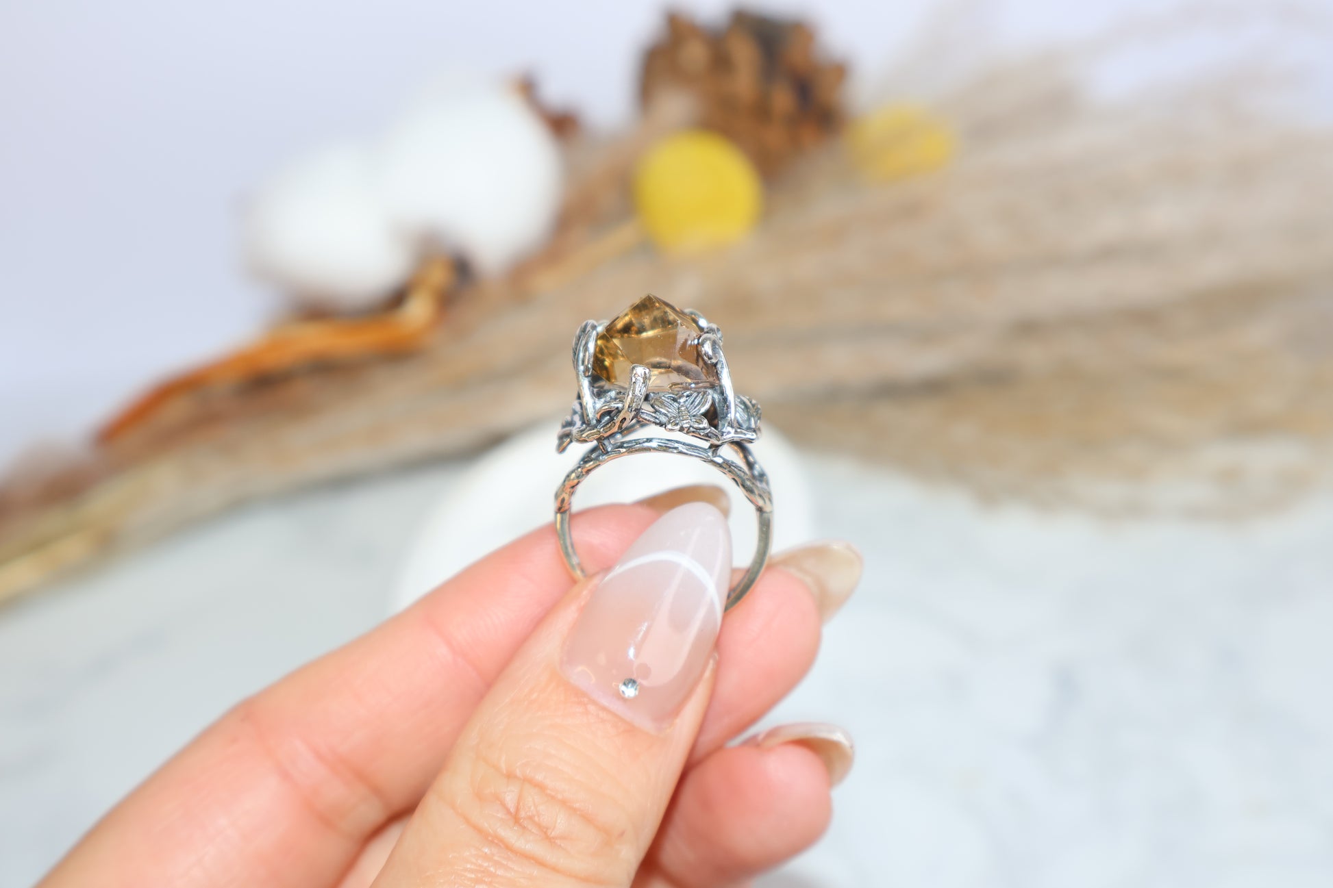 Ametrine ring worn on finger showing full gemstone and silver flower setting