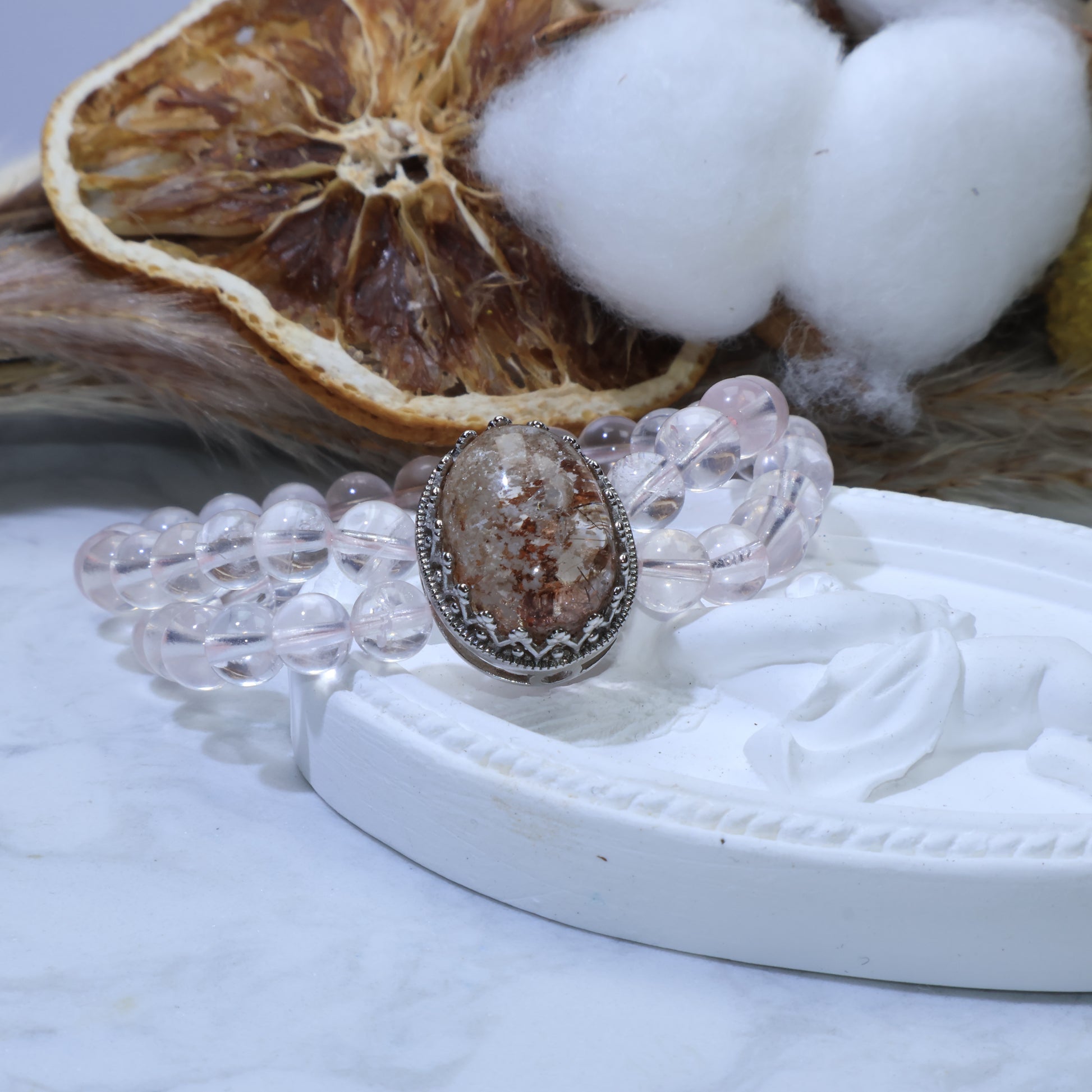 Close-up of double-strand bracelet featuring an oval Phantom Quartz cabochon with visible earthy and snowy inclusions, paired with soft pink Rose Quartz beads 2