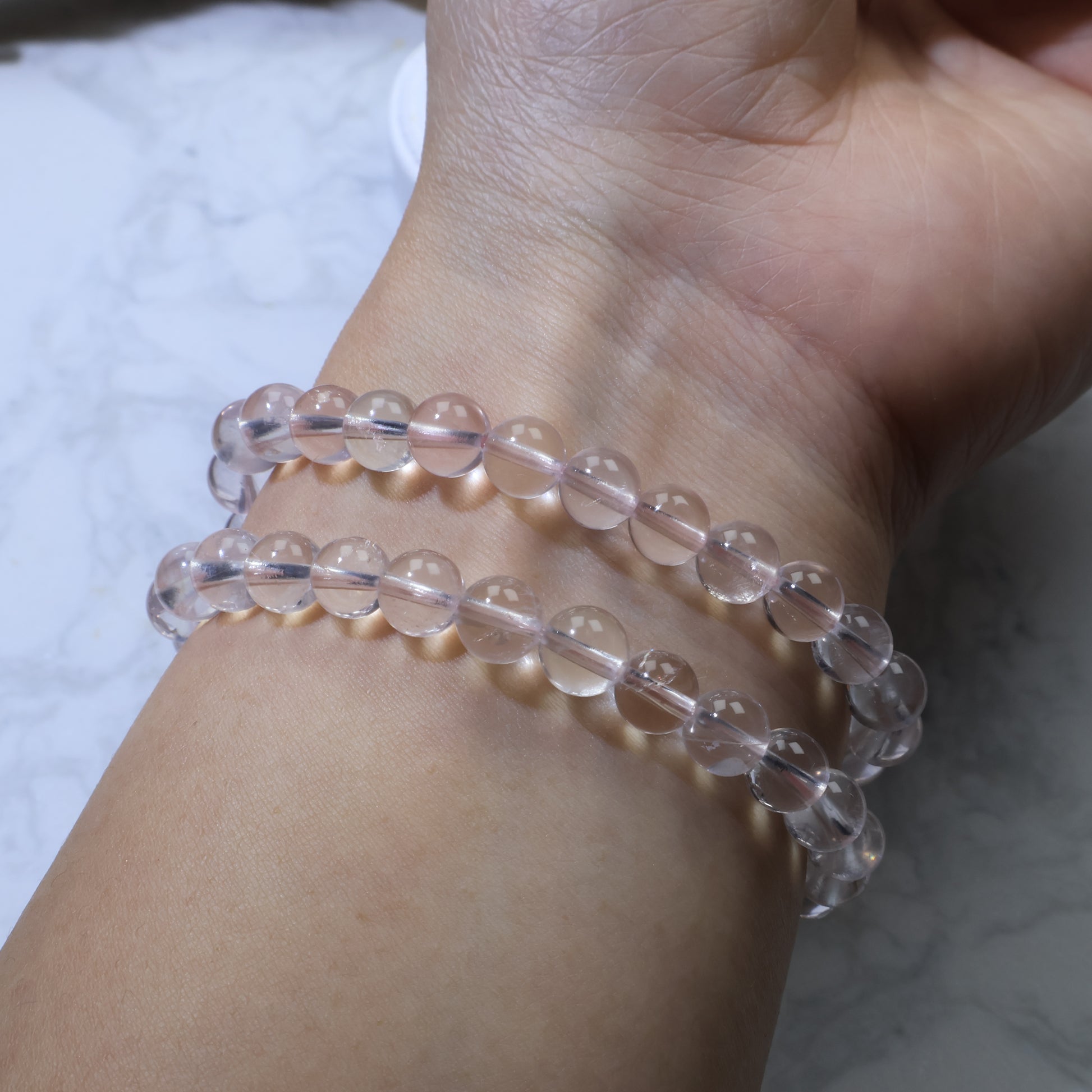 Back view of the bracelet on wrist, showing smooth and polished Rose Quartz beads