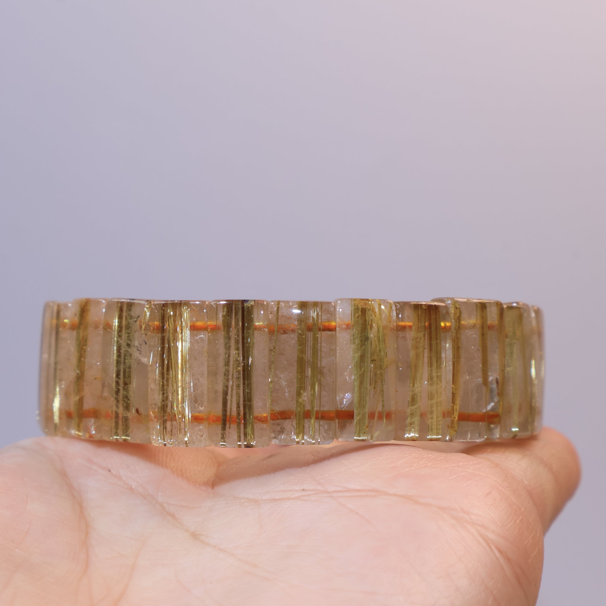 Golden Rutilated Quartz bracelet displayed across the palm.