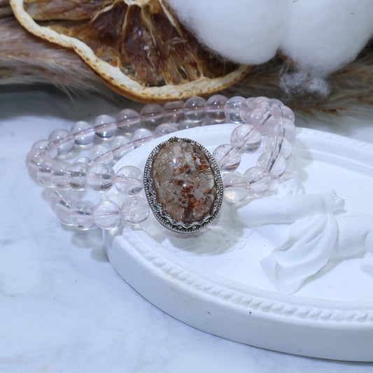 Close-up of double-strand bracelet featuring an oval Phantom Quartz cabochon with visible earthy and snowy inclusions, paired with soft pink Rose Quartz beads