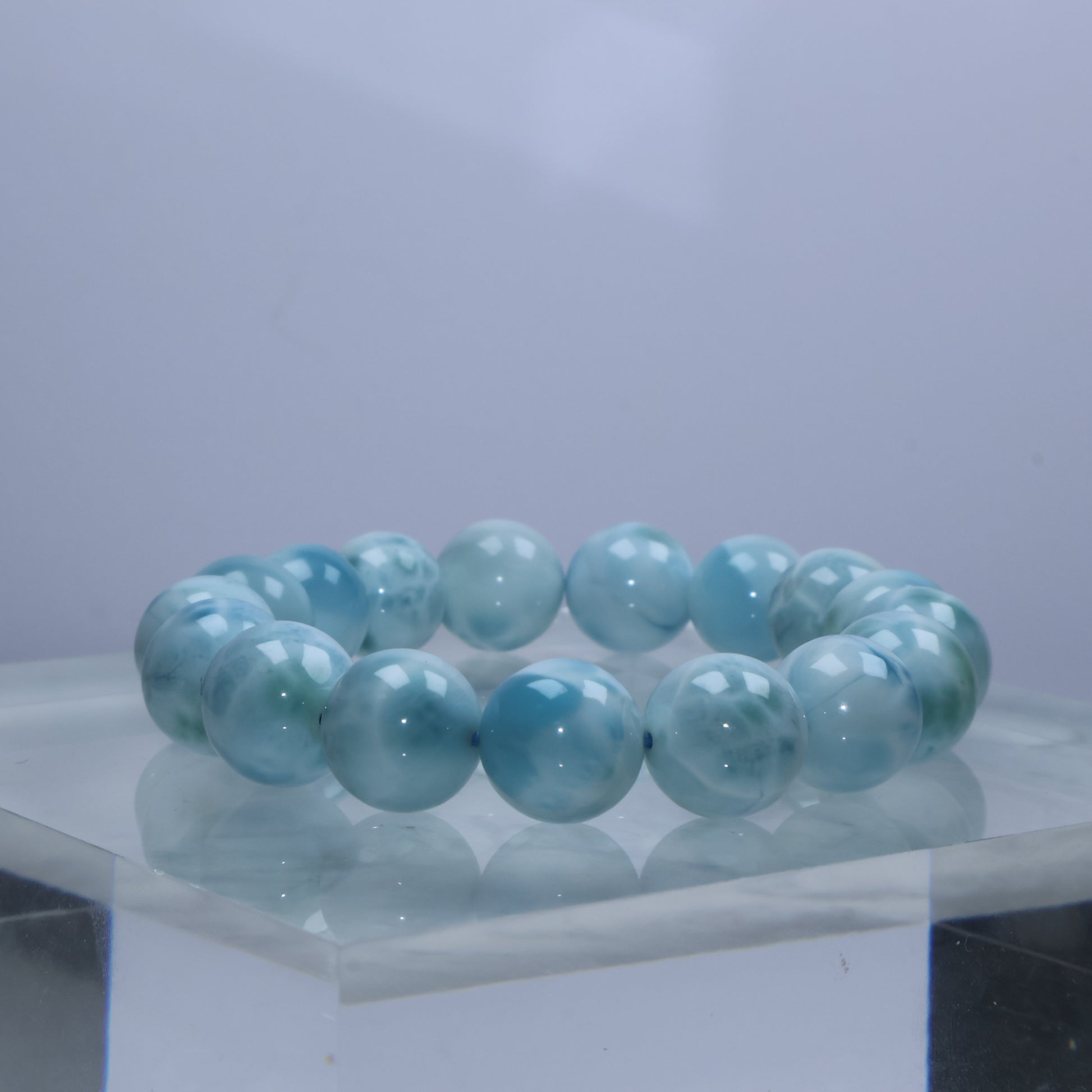 Angled shot of ocean-blue Larimar beads with glossy finish
