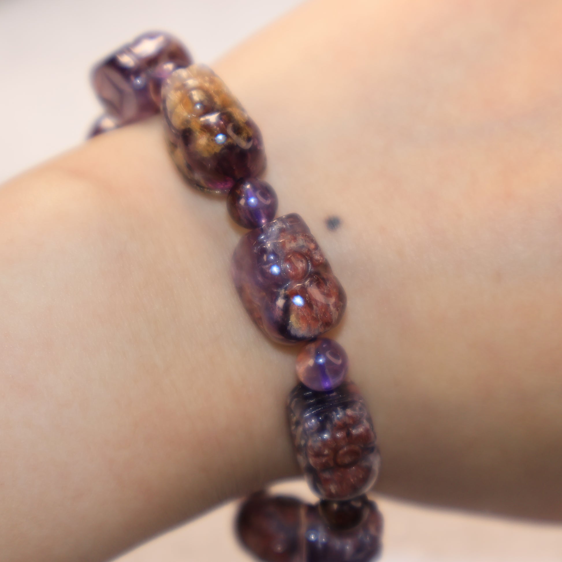 Artistic close-up of translucent Purple Phantom Quartz Pixiu bracelet on wrist