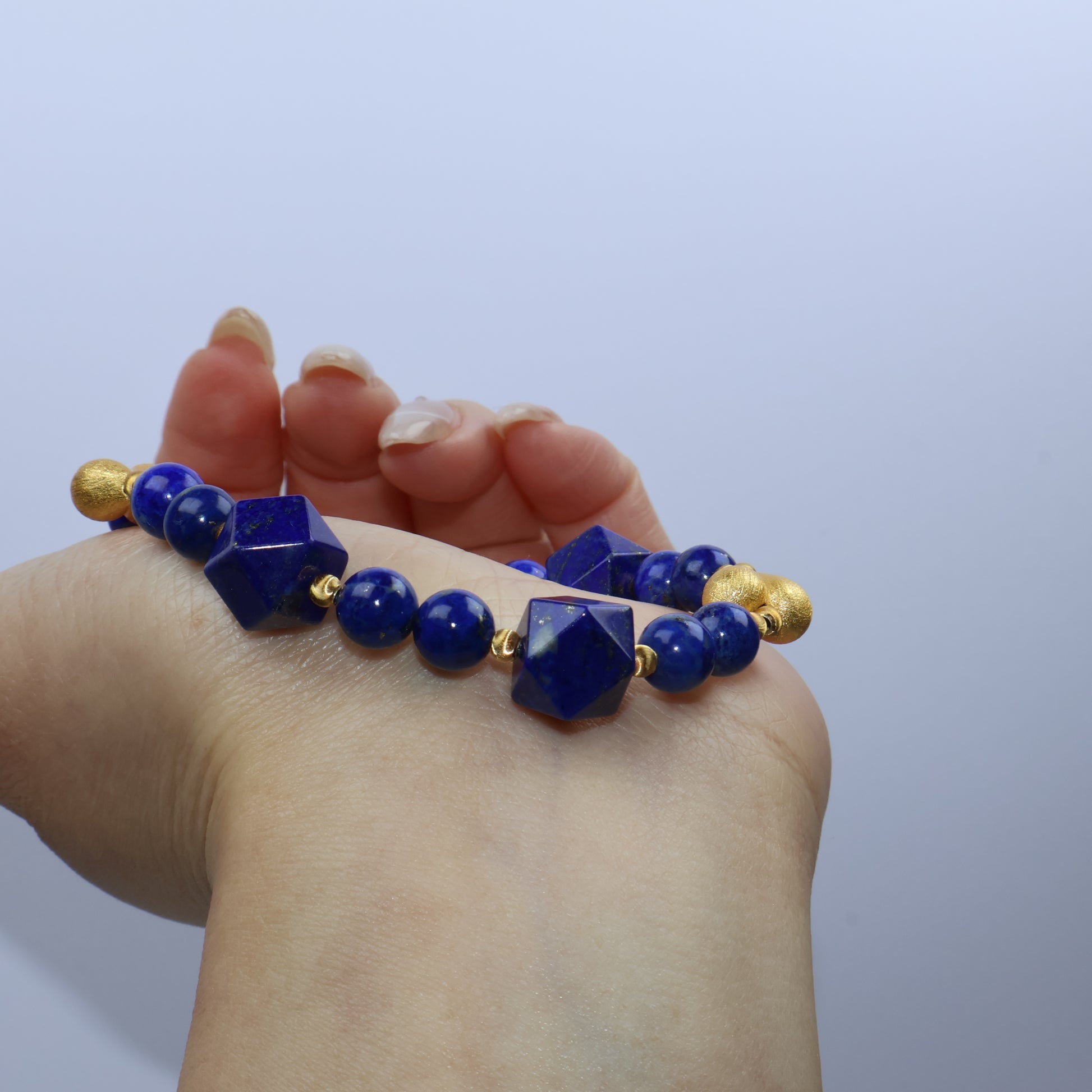 Side view of bracelet resting on wrist, highlighting gold-silver contrast and dimensional cut