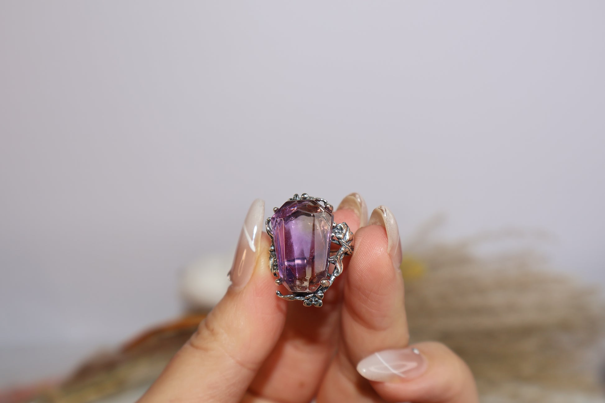 Close-up of freeform faceted Ametrine crystal in oxidized silver botanical setting