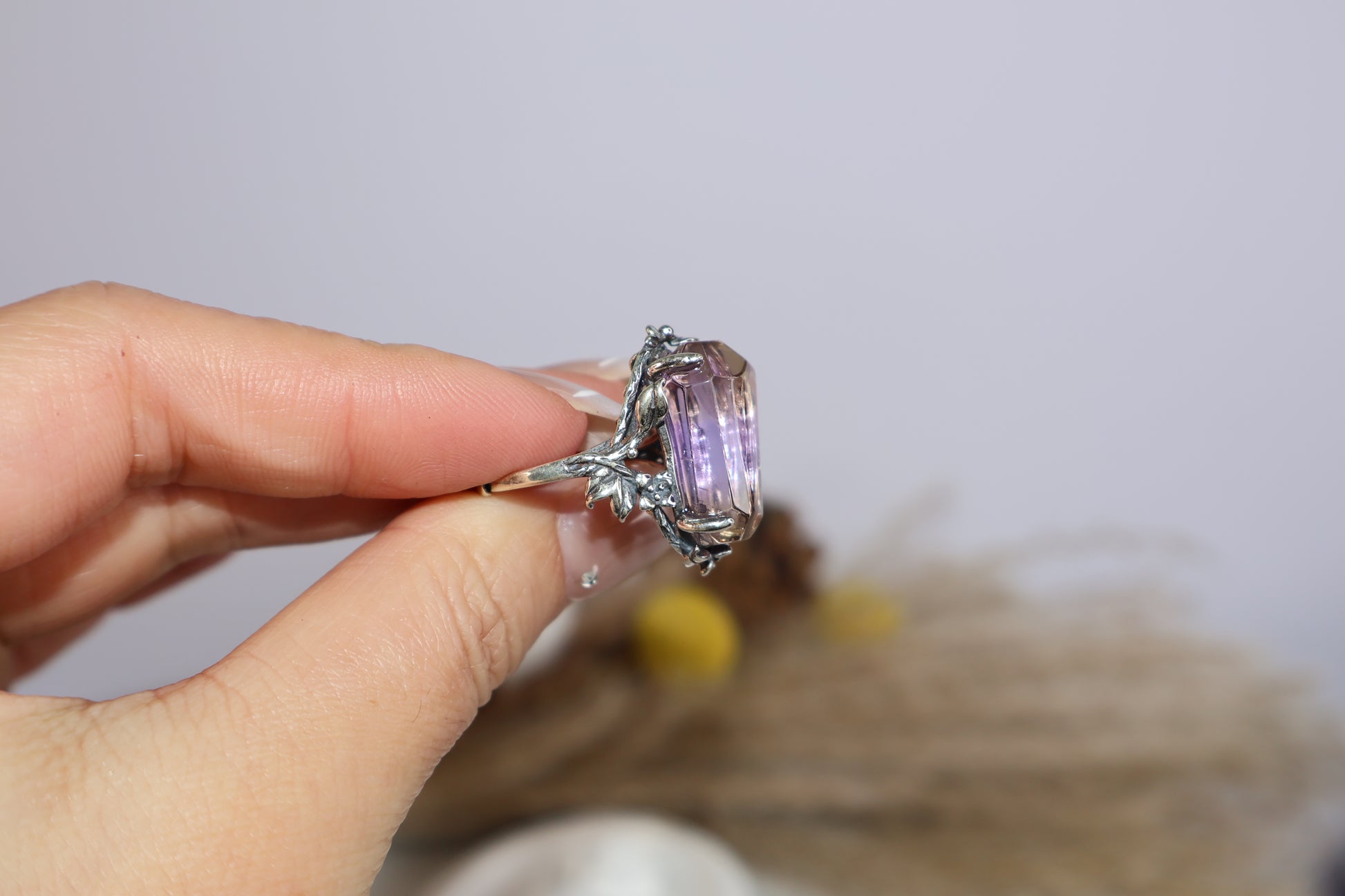 Handheld view of purple-golden Ametrine ring with antique silver design