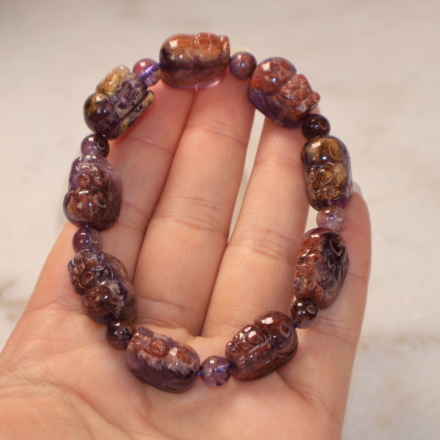 Handheld Purple Phantom Quartz Pixiu bracelet with natural purple and earthy crystal tones