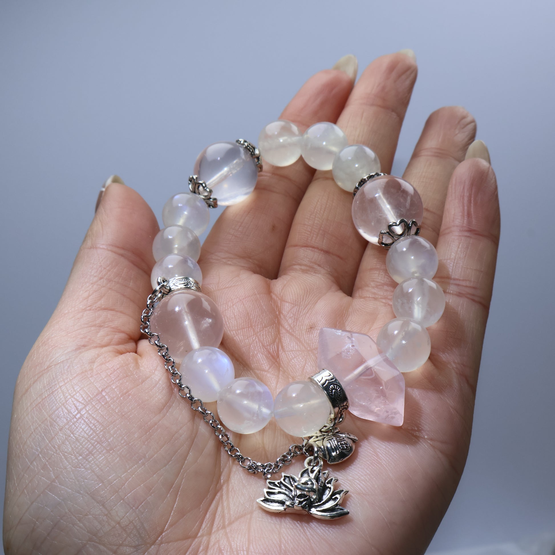 Handheld view of moonstone and rose quartz bracelet with fox charm