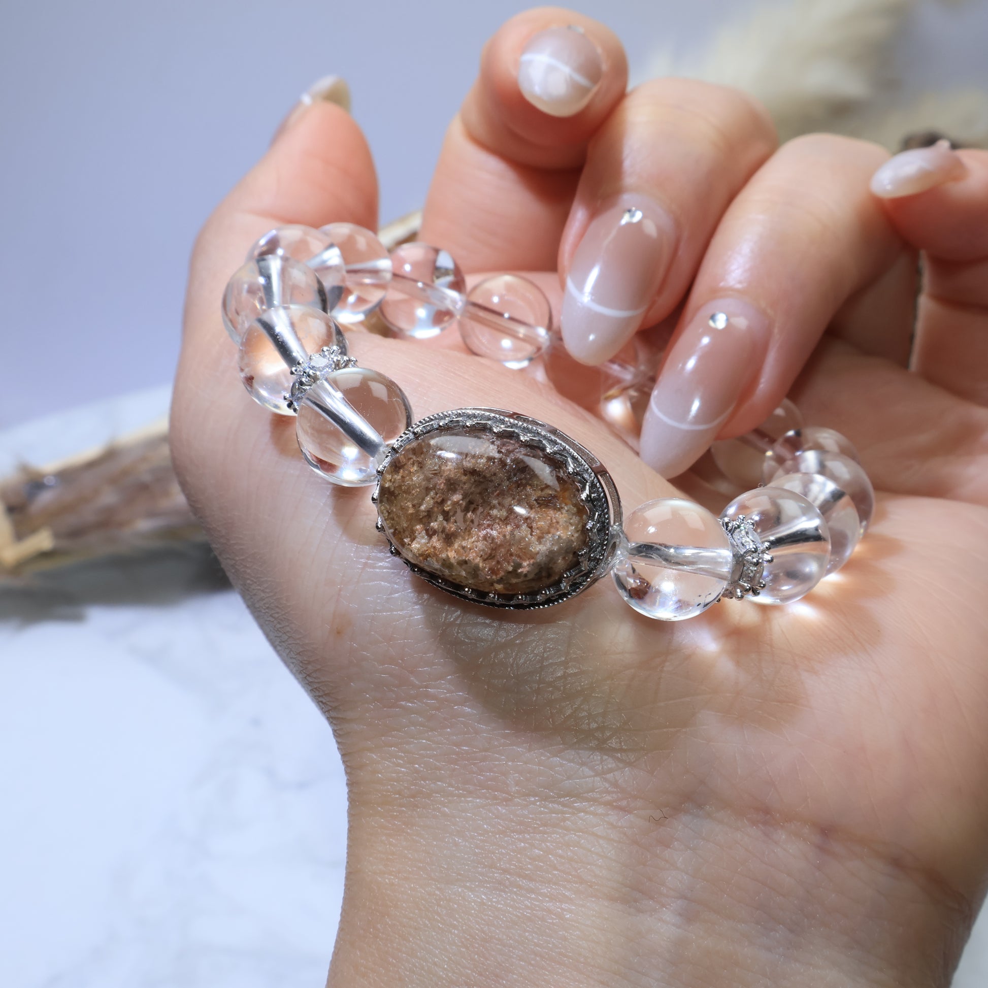 Side profile of bracelet on wrist, showing silver bezel design and phantom inclusions in the stone