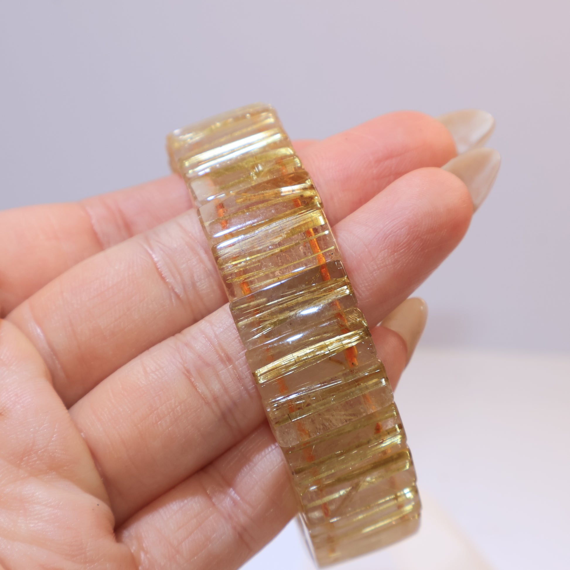 Golden Rutilated Quartz bracelet shining under light with golden needle-like inclusions.