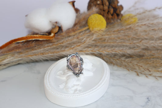 Faceted oval Ametrine ring on angel dish display, front view