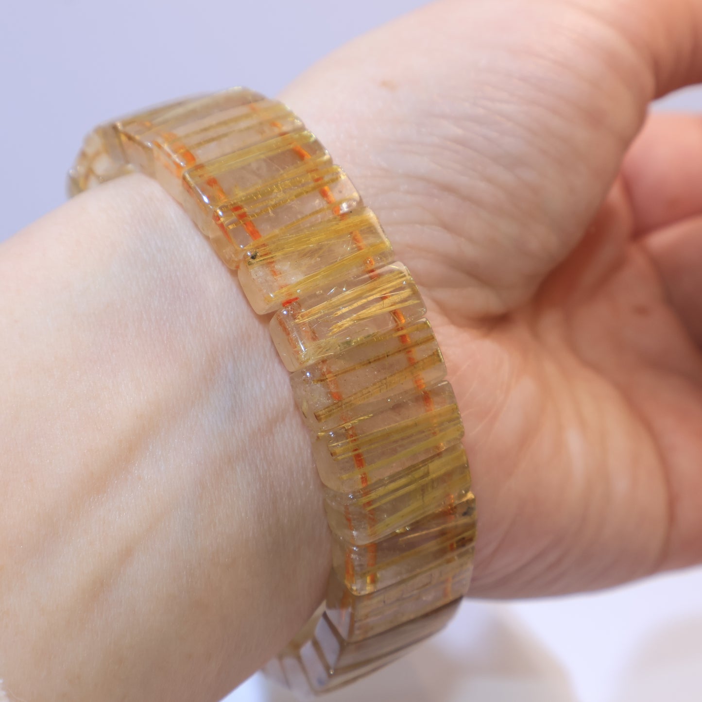 Wrist shot of the bracelet highlighting golden rutile threads.