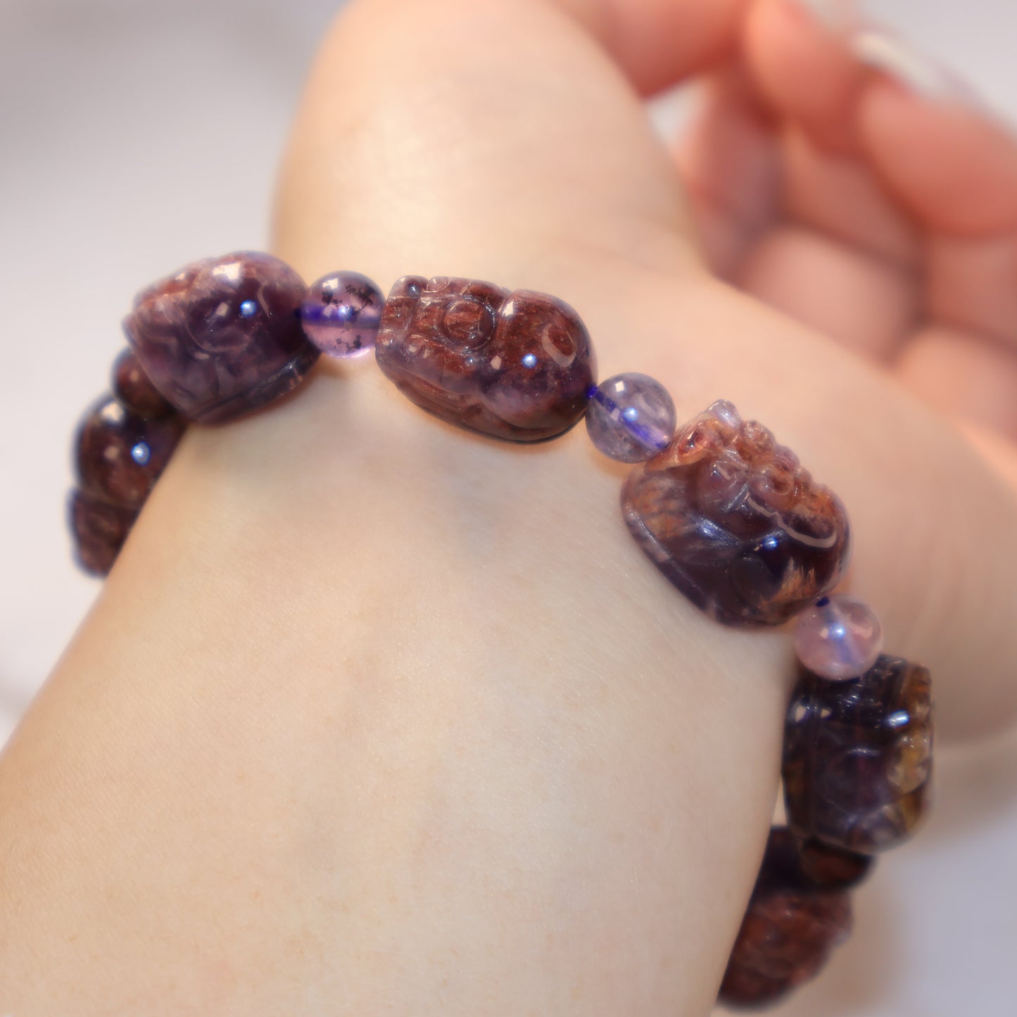 Artistic close-up of translucent Purple Phantom Quartz Pixiu bracelet on wrist