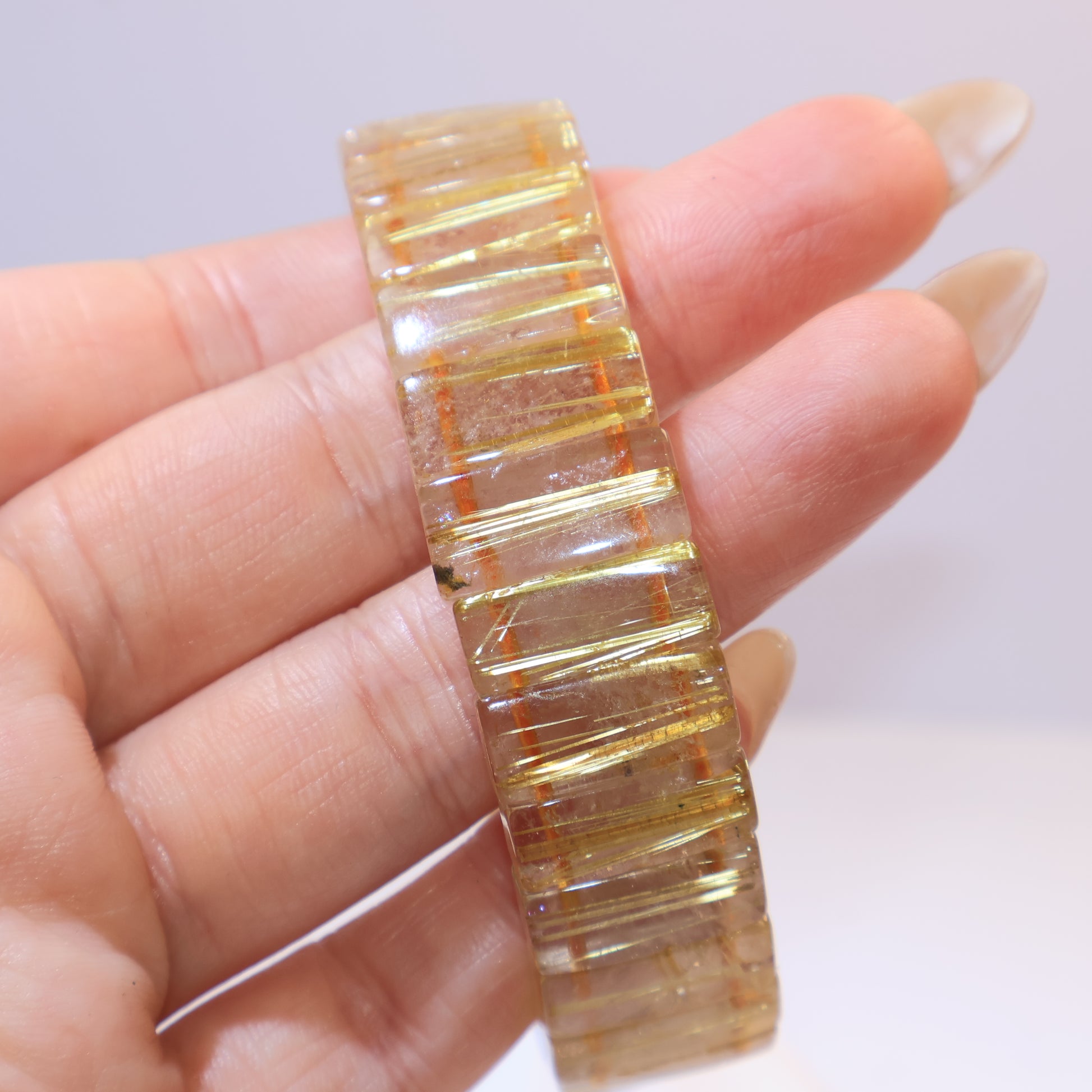 Close-up of the rectangular golden rutilated quartz bracelet showing clear rutile inclusions.