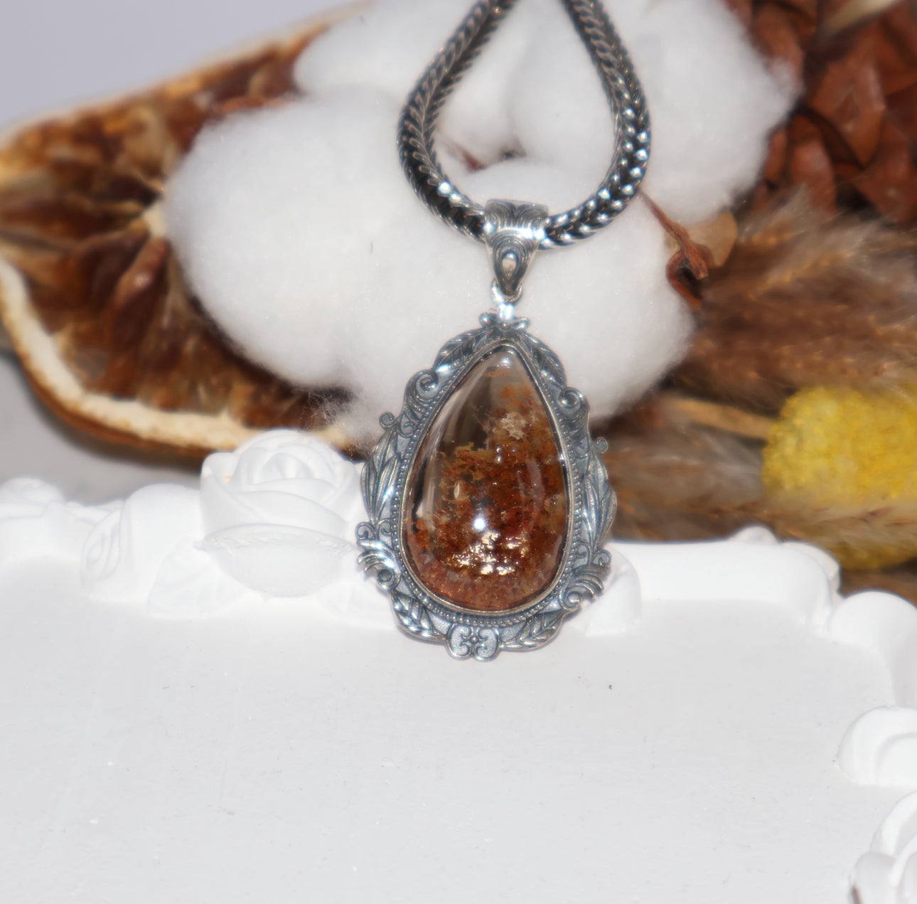 Artistic flat lay of Phantom Quartz pendant with cotton and natural props