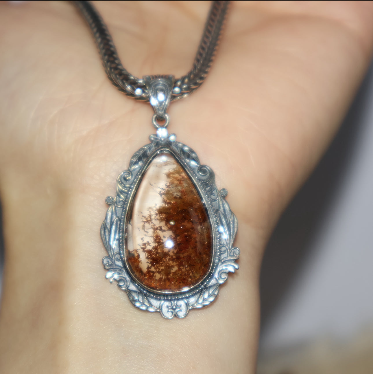 Handheld view of Phantom Quartz pendant, showing scale and clarity