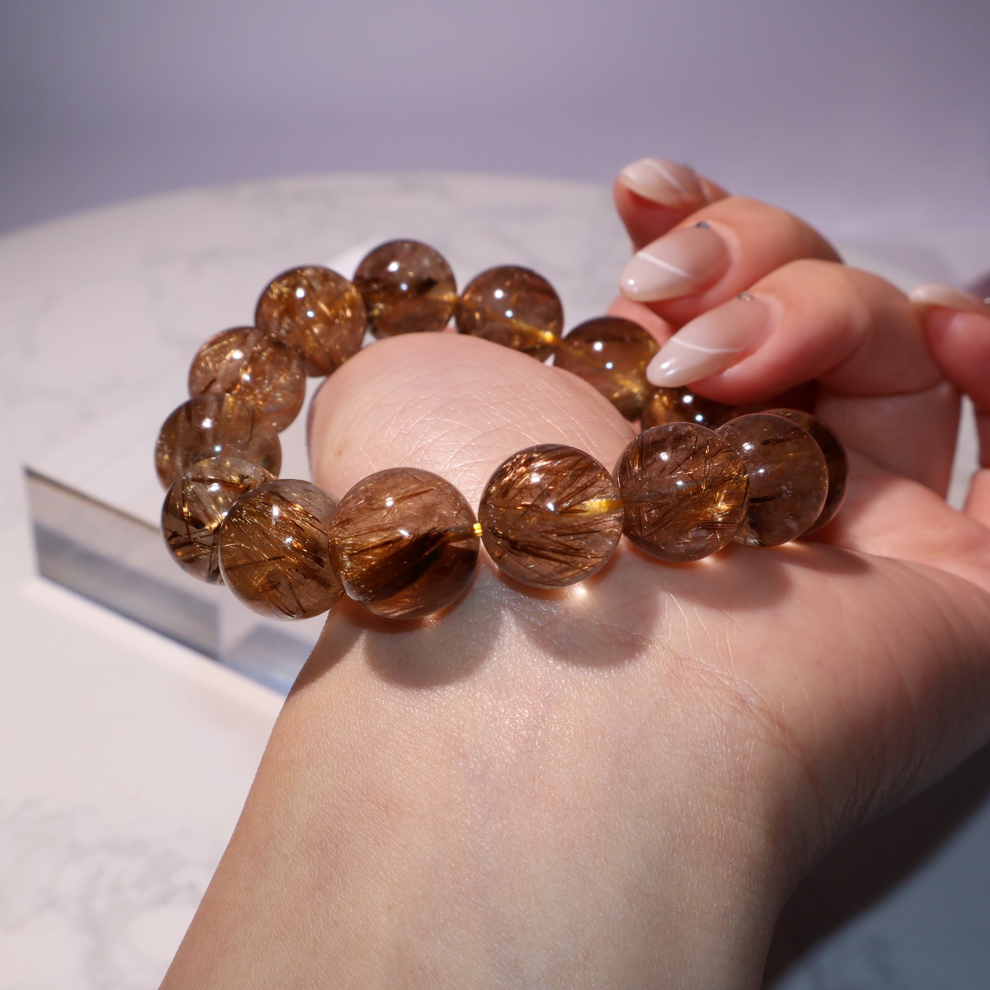 Close-up angle highlighting internal rutile inclusions of brown rutilated quartz beads