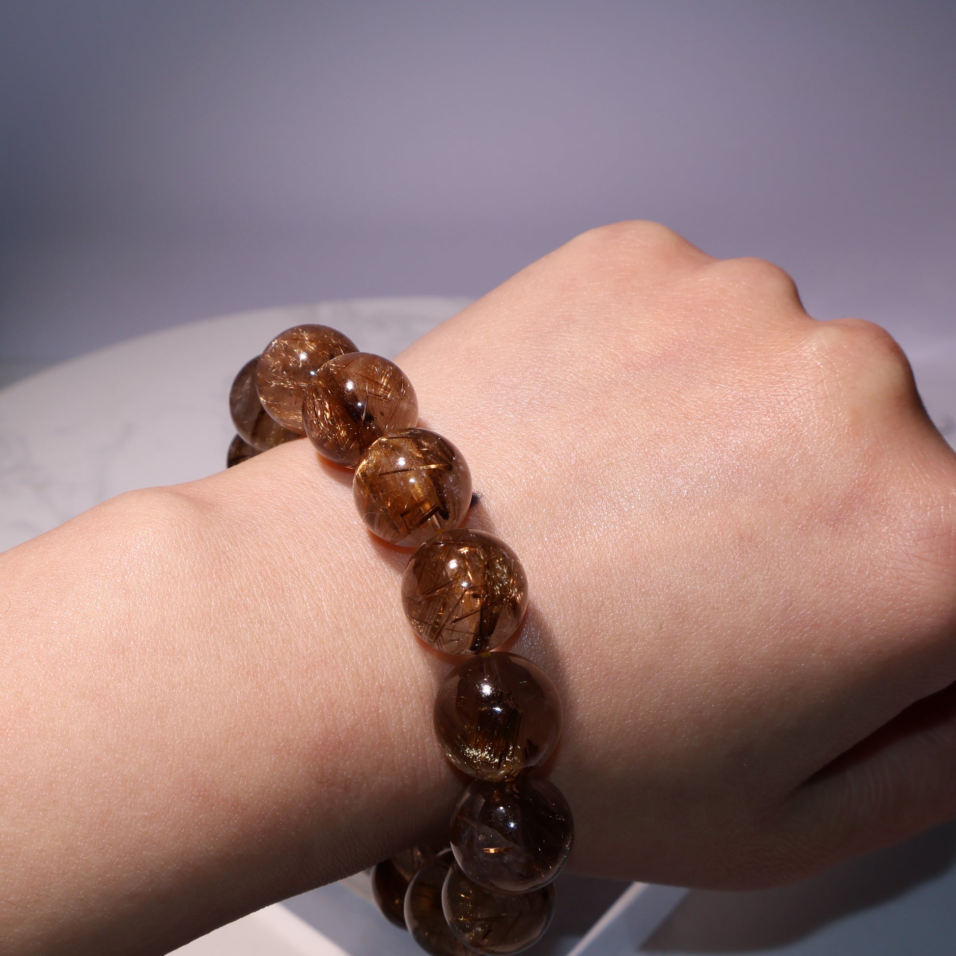 Rutilated quartz bracelet worn on wrist – warm tone under studio lighting