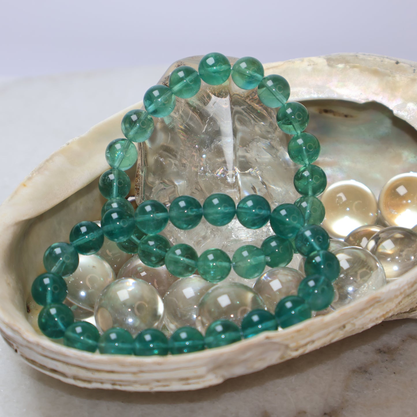 Two Natural 9mm Green Fluorite Bracelets Displayed in Seashell