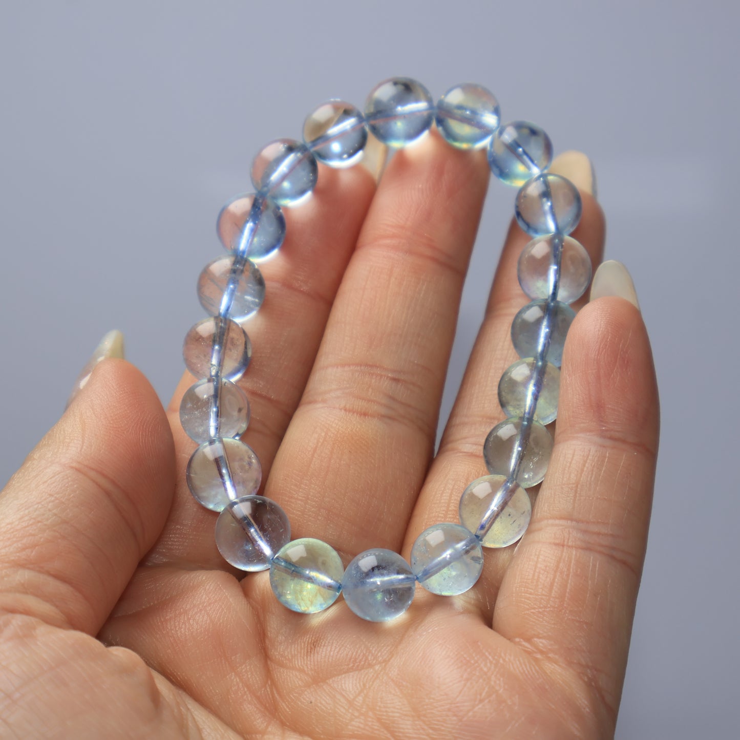 Genuine 9mm Aquamarine bracelet held in hand showing natural clarity