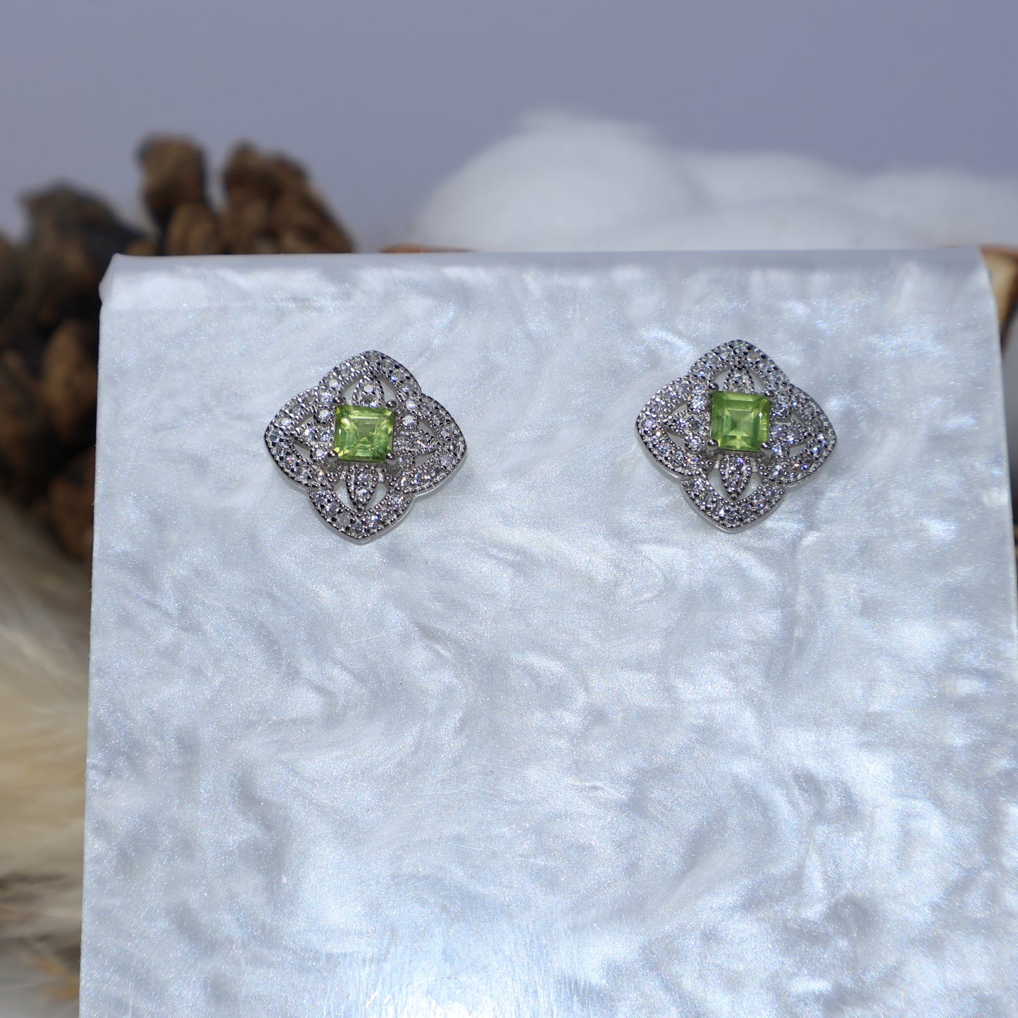 Close-up of genuine peridot earrings in sterling silver setting