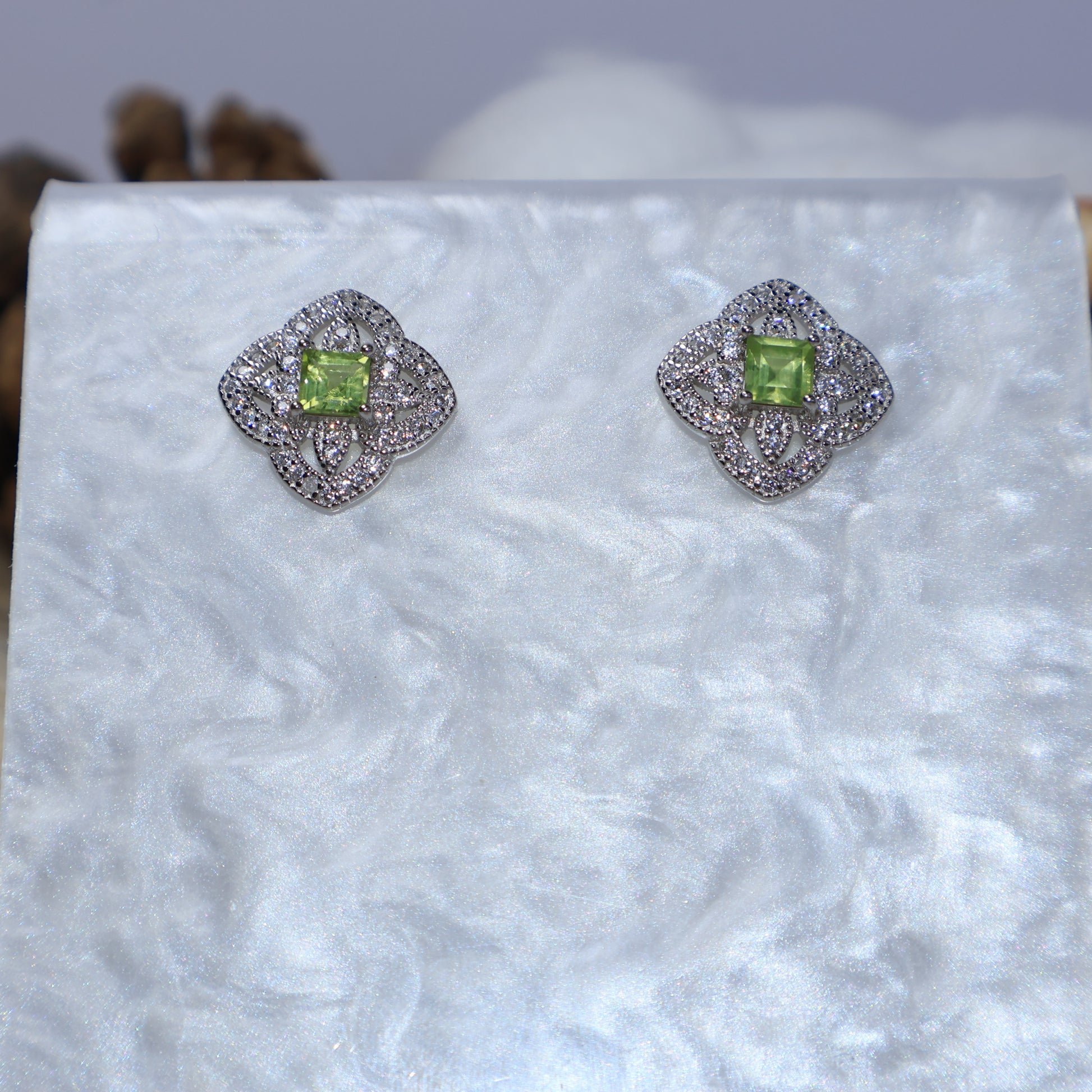 Detailed view of natural peridot stud earrings with cubic zirconia