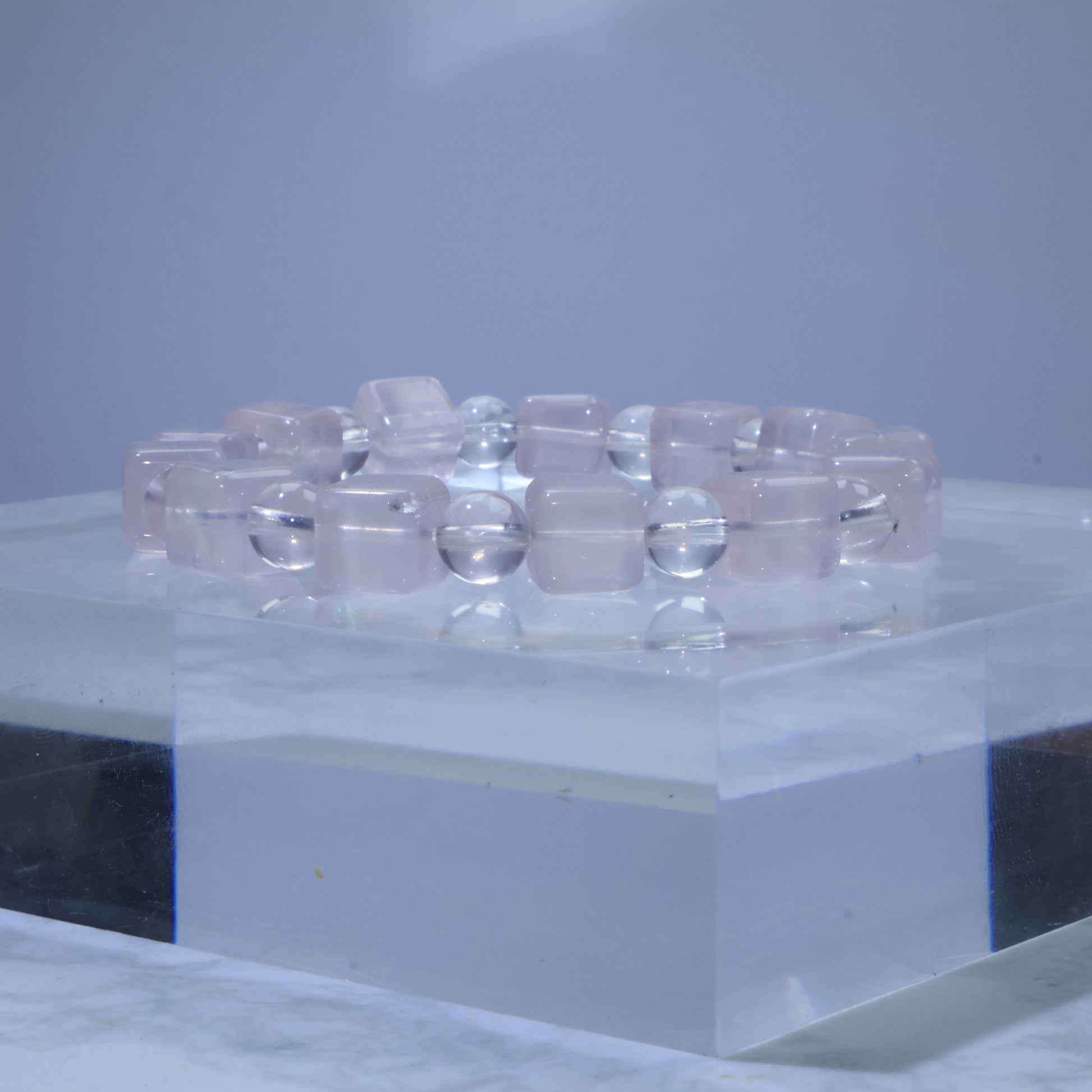 Side-angle view of Rose Quartz bracelet showing alternating square-cut and round beads with soft pink tone.