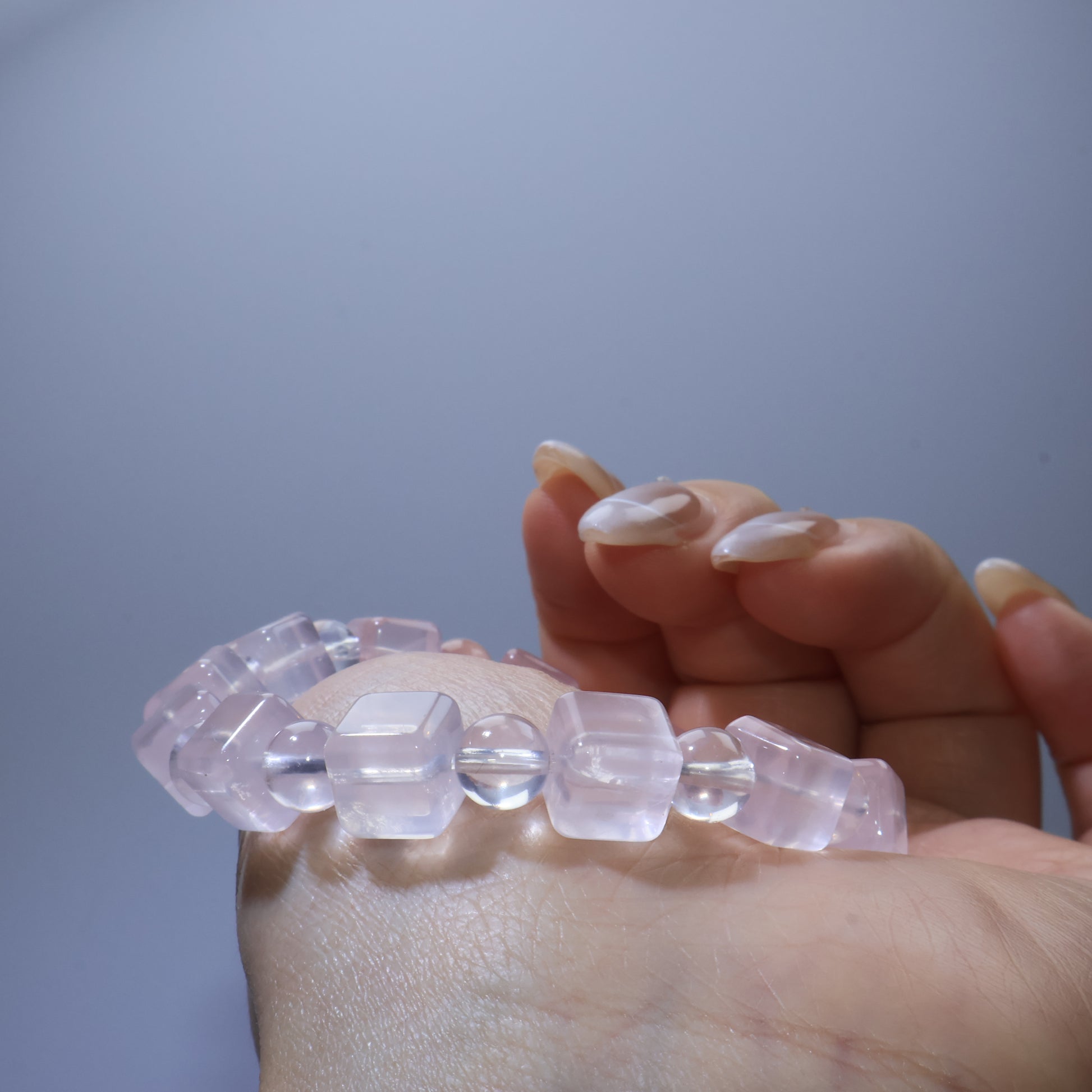 Close-up of Rose Quartz bracelet on wrist, focusing on the interplay between square and round beads.