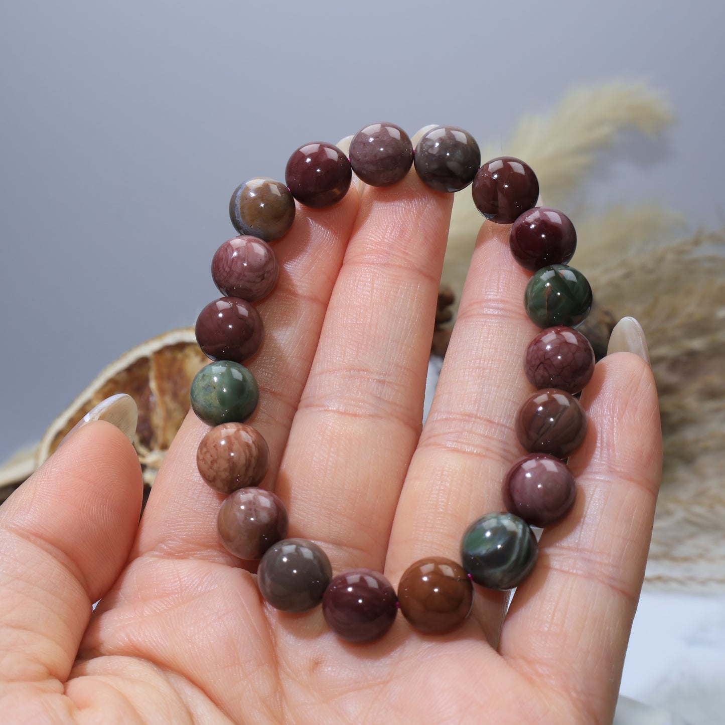 Handheld view of Alxa Agate bracelet, highlighting polished beads and color variety