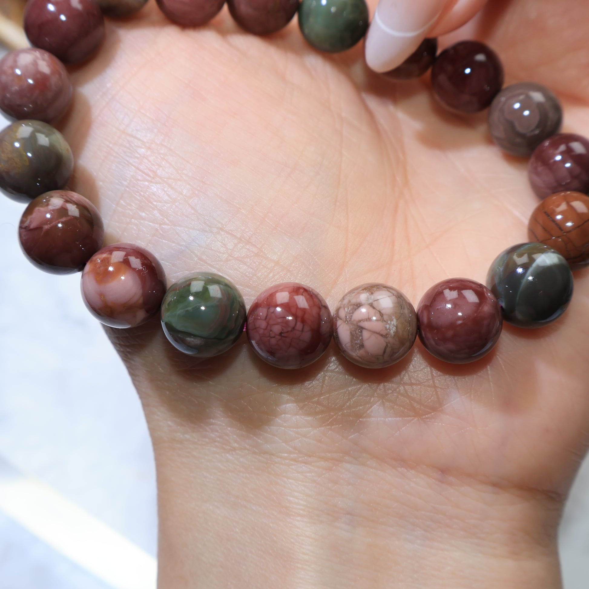 Close-up of beads with unique patterns and earthy shades on palm