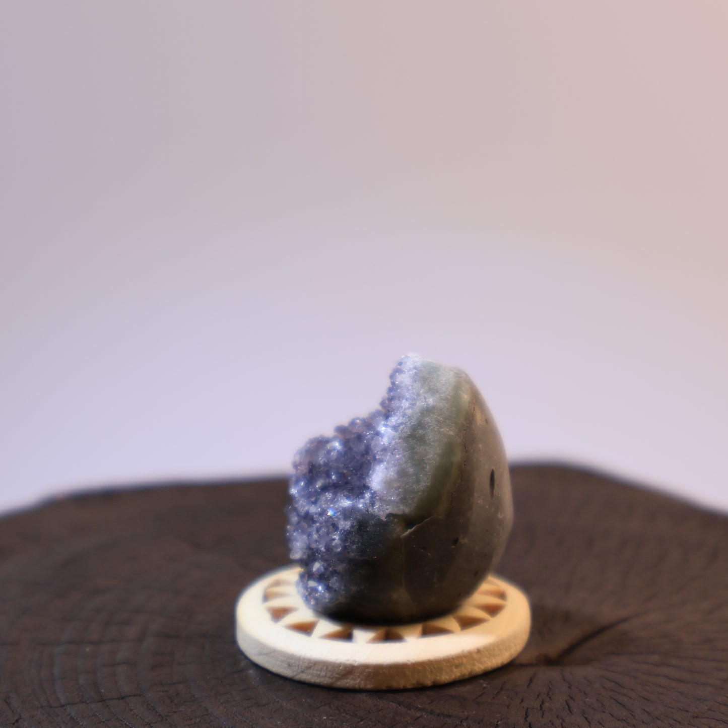 Another side angle of grey quartz geode egg with crystal exposure.