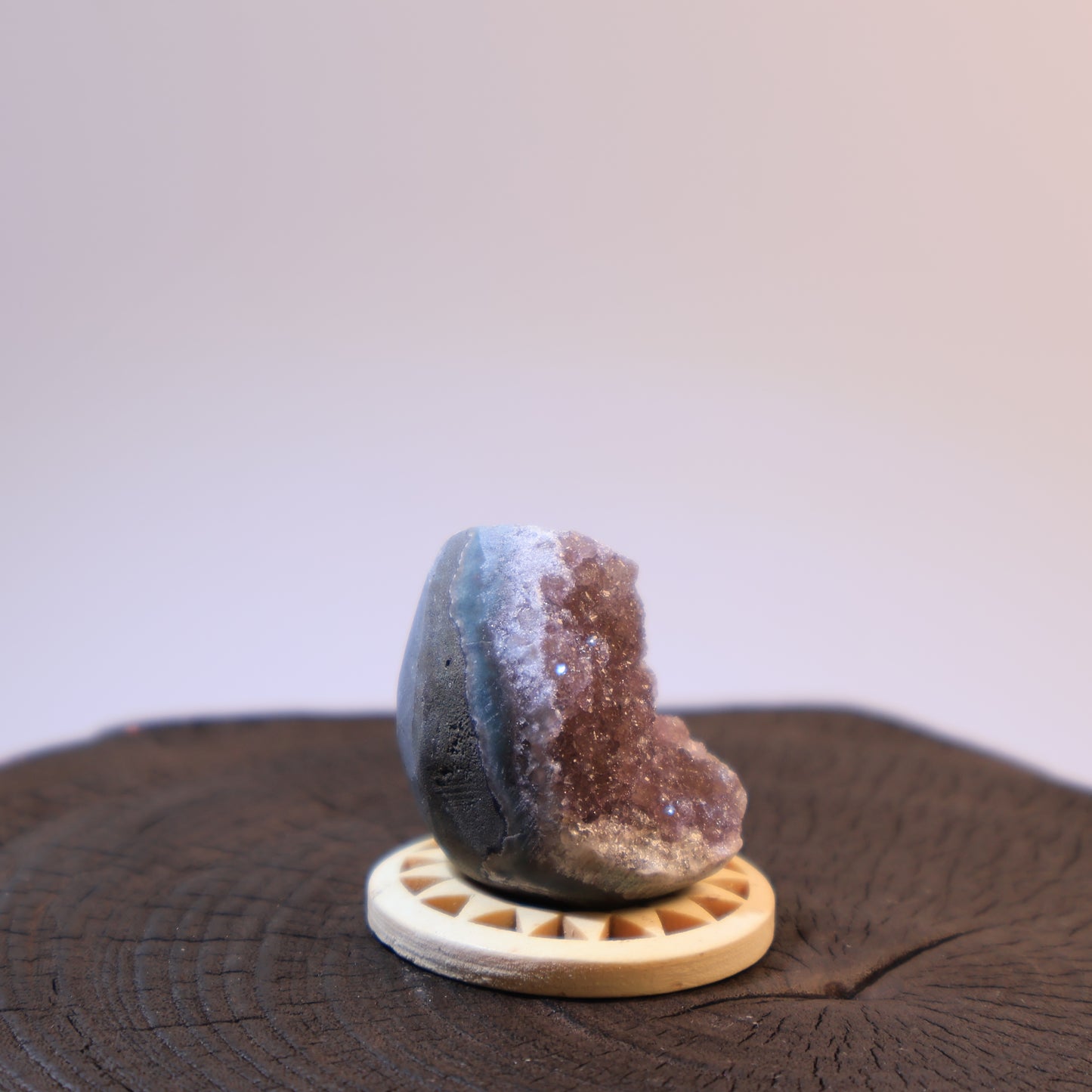Side view of purple amethyst geode egg showing crystal opening.