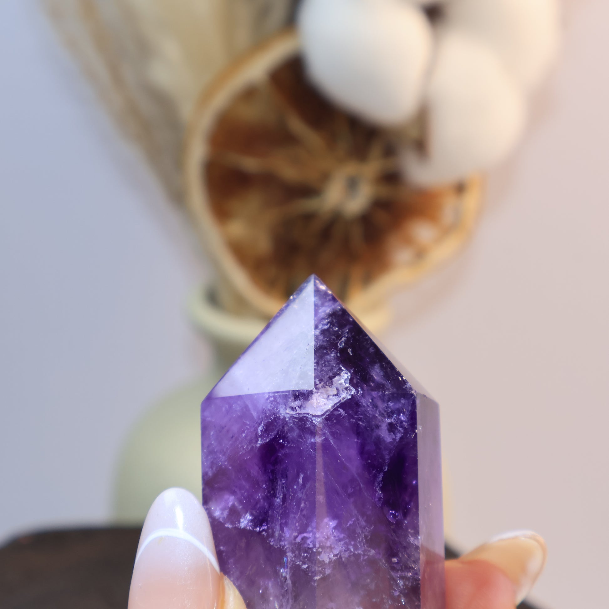 Detailed shot of Amethyst tower in hand, natural inclusions visible.