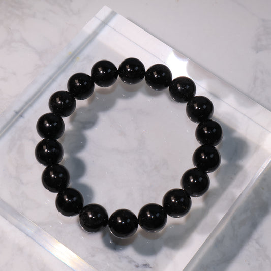 Black Rutilated Quartz Bracelet – 11mm beads displayed on a clear acrylic stand.