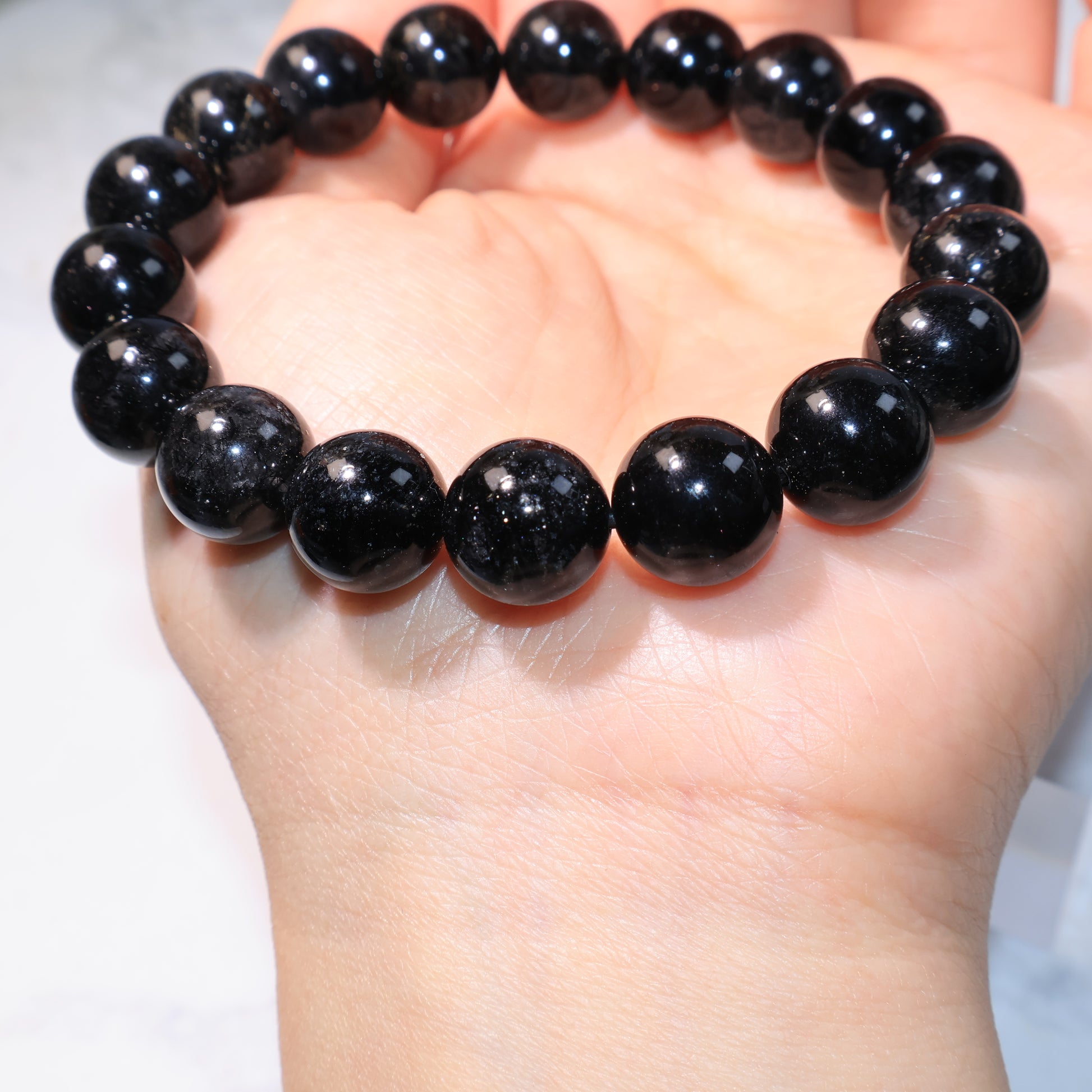 Black Rutilated Quartz Bracelet – beads cluster reflecting strong light.