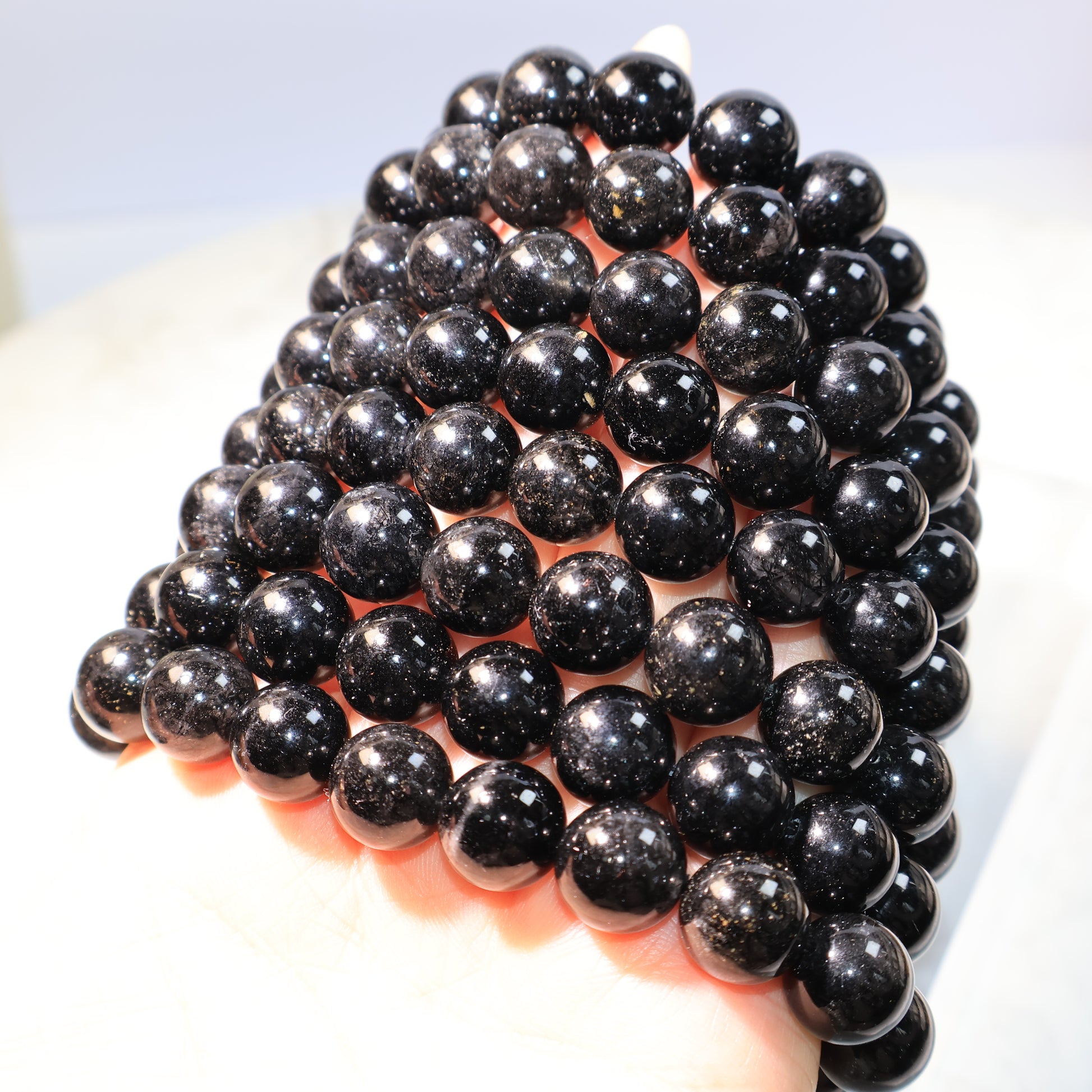 Multiple Black Rutilated Quartz Bracelets – stacked together with sparkling reflections.