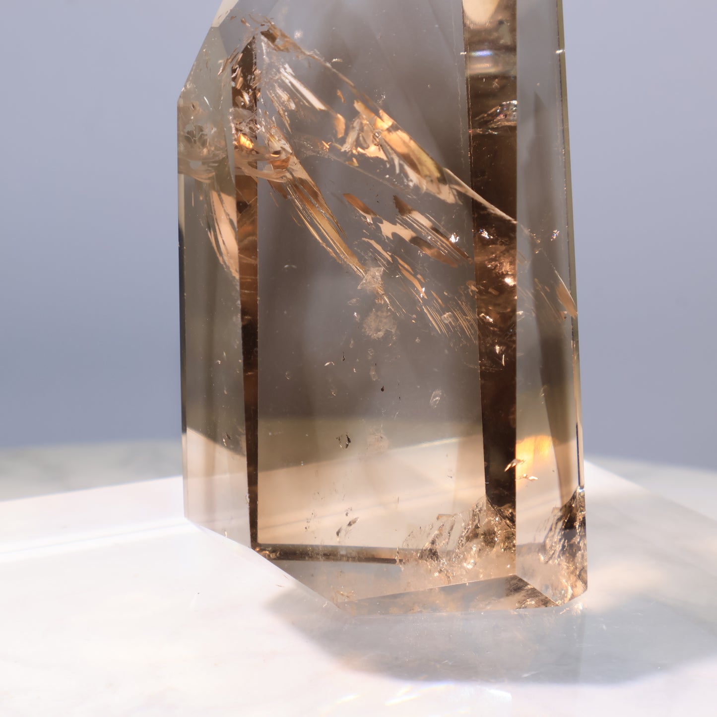Smoky Quartz Tower – polished crystal surface reflecting light.