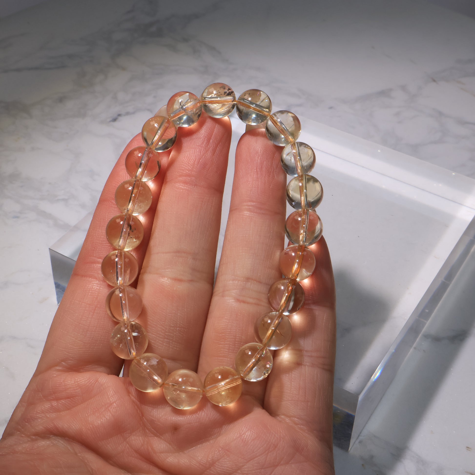 Citrine bracelet on hand, showing cotton-like inclusions and gentle golden clarity.
