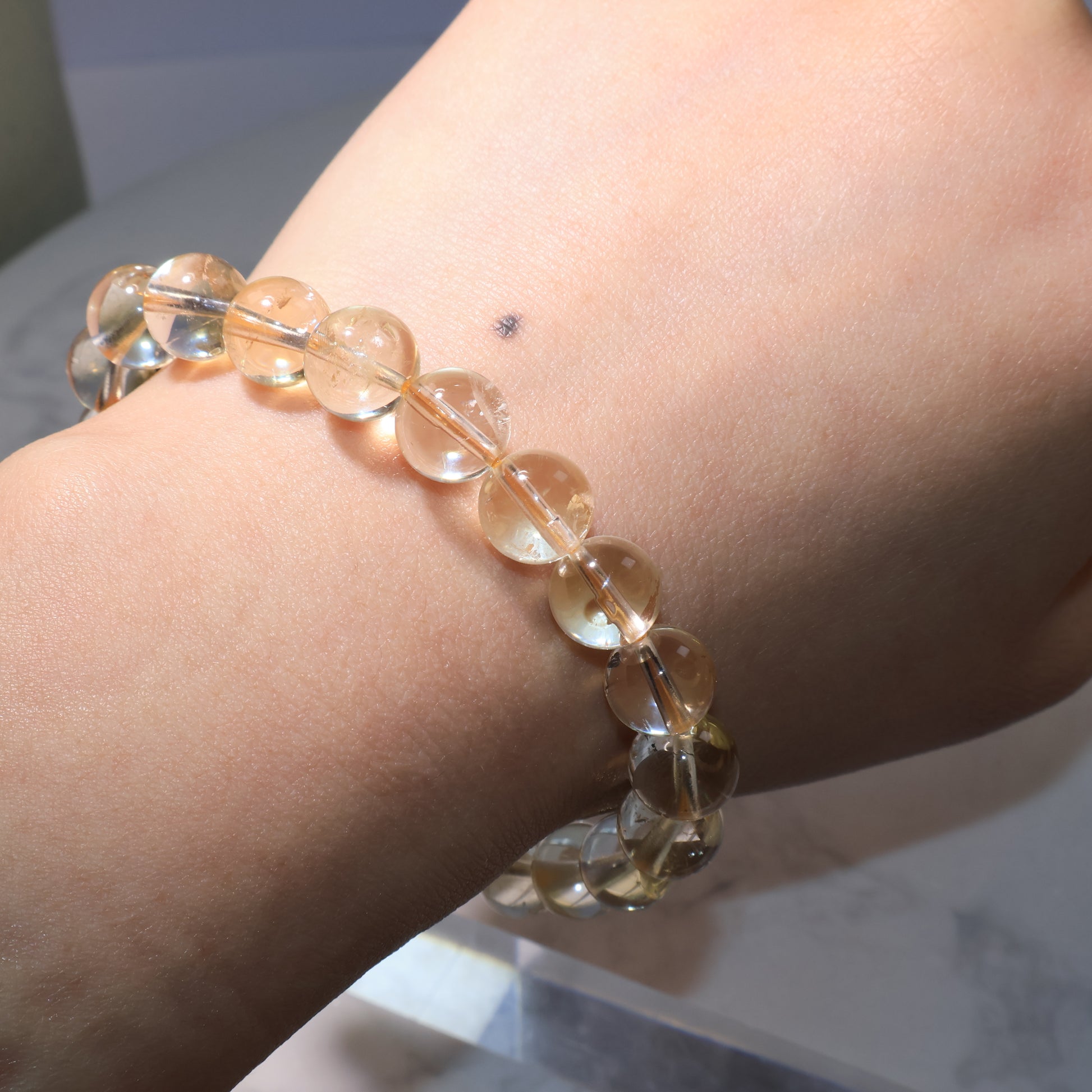 Citrine bracelet worn on wrist, natural inclusions creating unique inner reflections.
