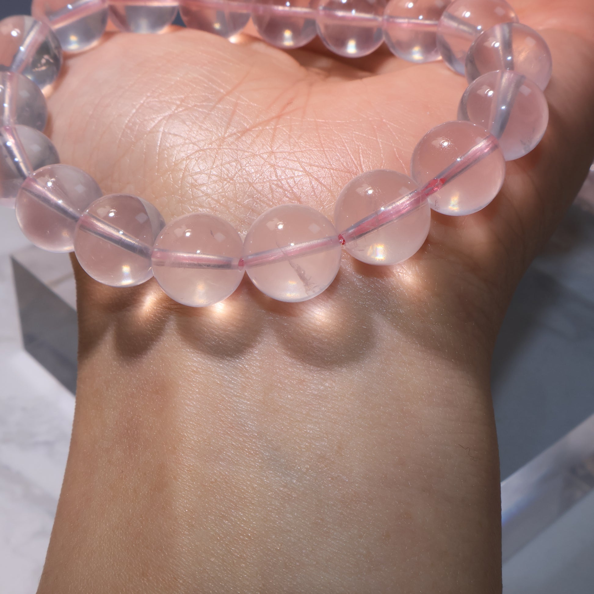 Detailed shot of bracelet beads, showing natural inclusions inside Rose Quartz.