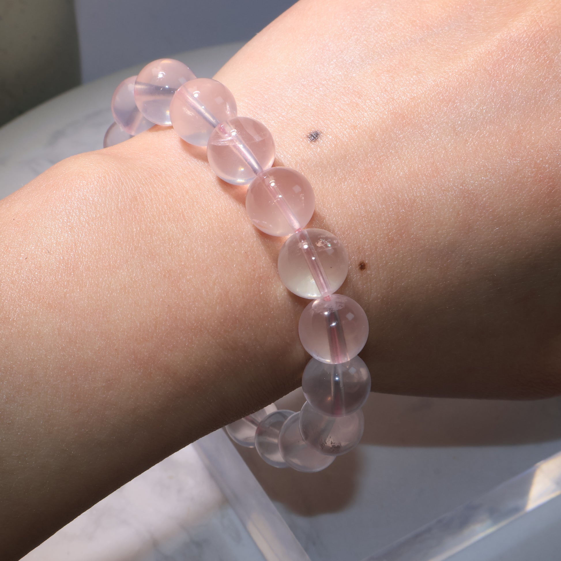 Close-up of Rose Quartz bracelet on wrist, highlighting bead clarity and starlight glow.