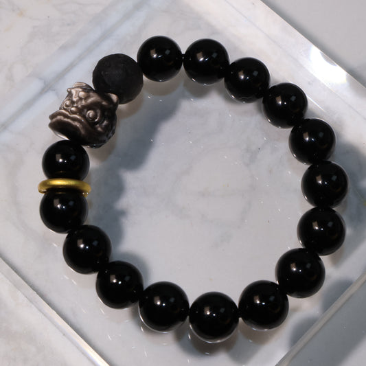 Meteor Lion Obsidian Bracelet with Pixiu Lion carving, meteorite-style bead, and golden accent – 黑曜石隕石醒獅手串平放展示。