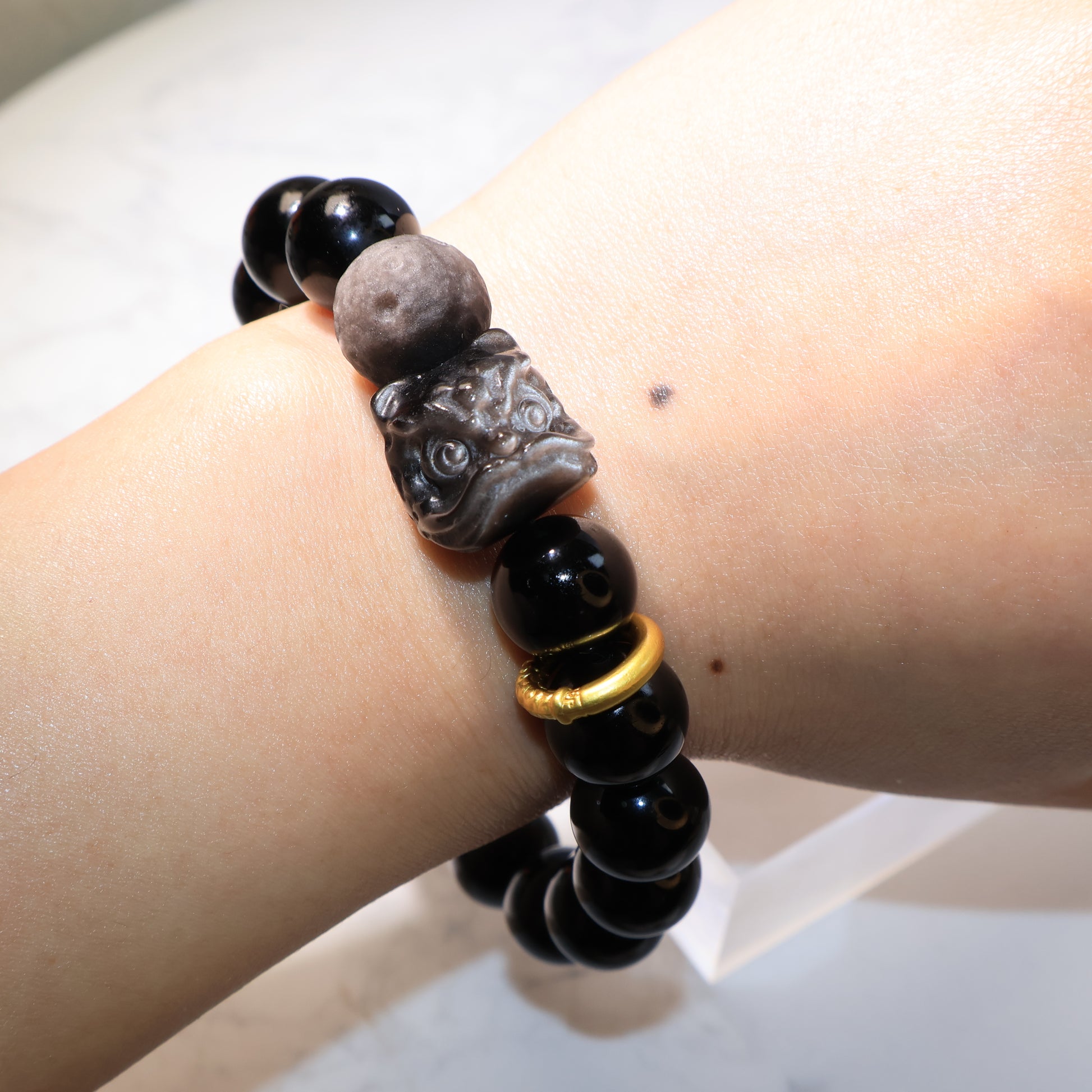 Obsidian Pixiu Lion bracelet worn on wrist, elegant and powerful look – 黑曜石醒獅隕石珠手串佩戴於手腕正面。