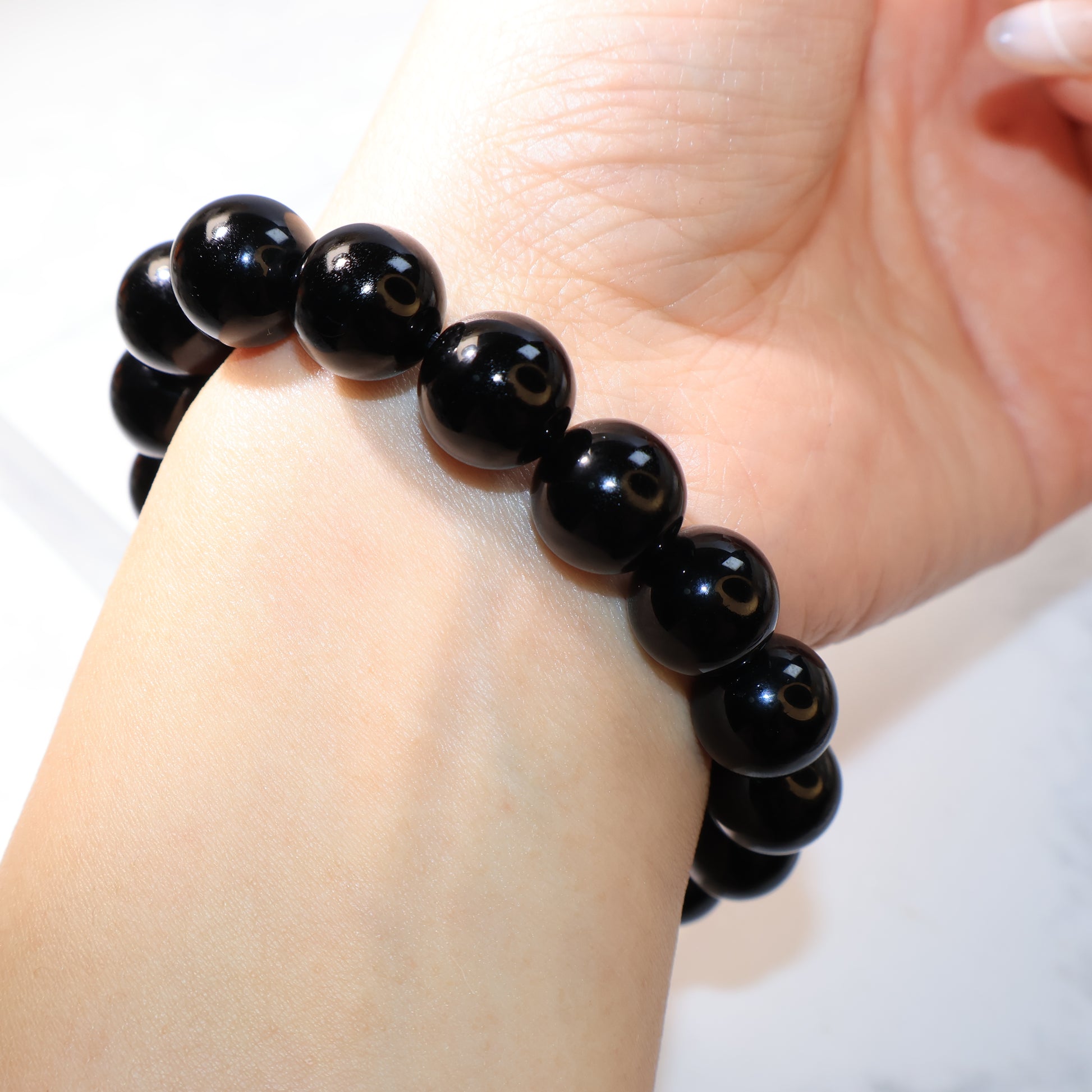 Back view of black obsidian bracelet beads on wrist – 黑曜石圓珠手串佩戴於手腕背面。