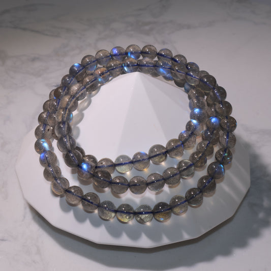 Labradorite bracelet with strong blue flashes on white stand｜白色底座上的拉長石手串，透度佳藍光強烈