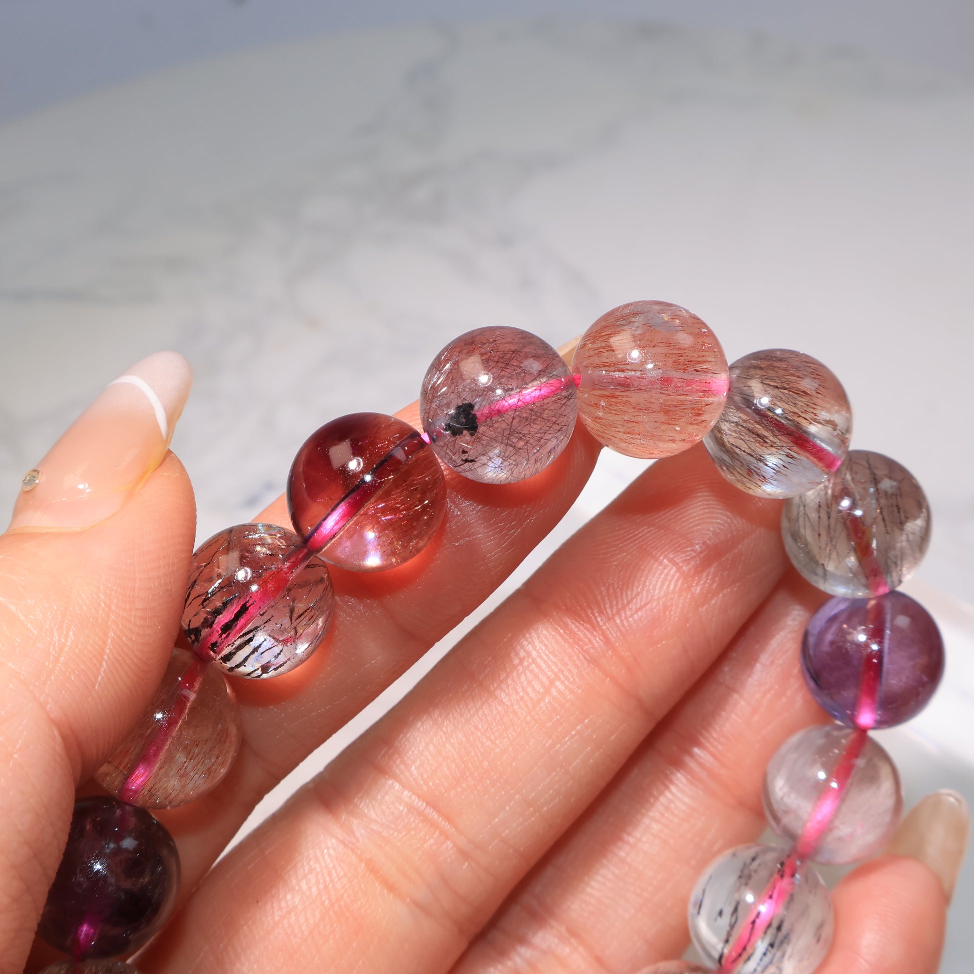 Bead close-up in hand, showing transparency and fine inclusions｜手中珠子特寫，晶體清透帶細緻內含物